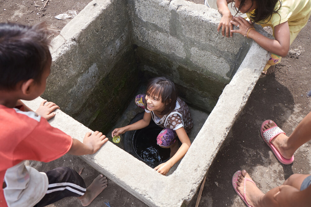  Children play in the village well. Their only water source is polluted and undrinkable. 