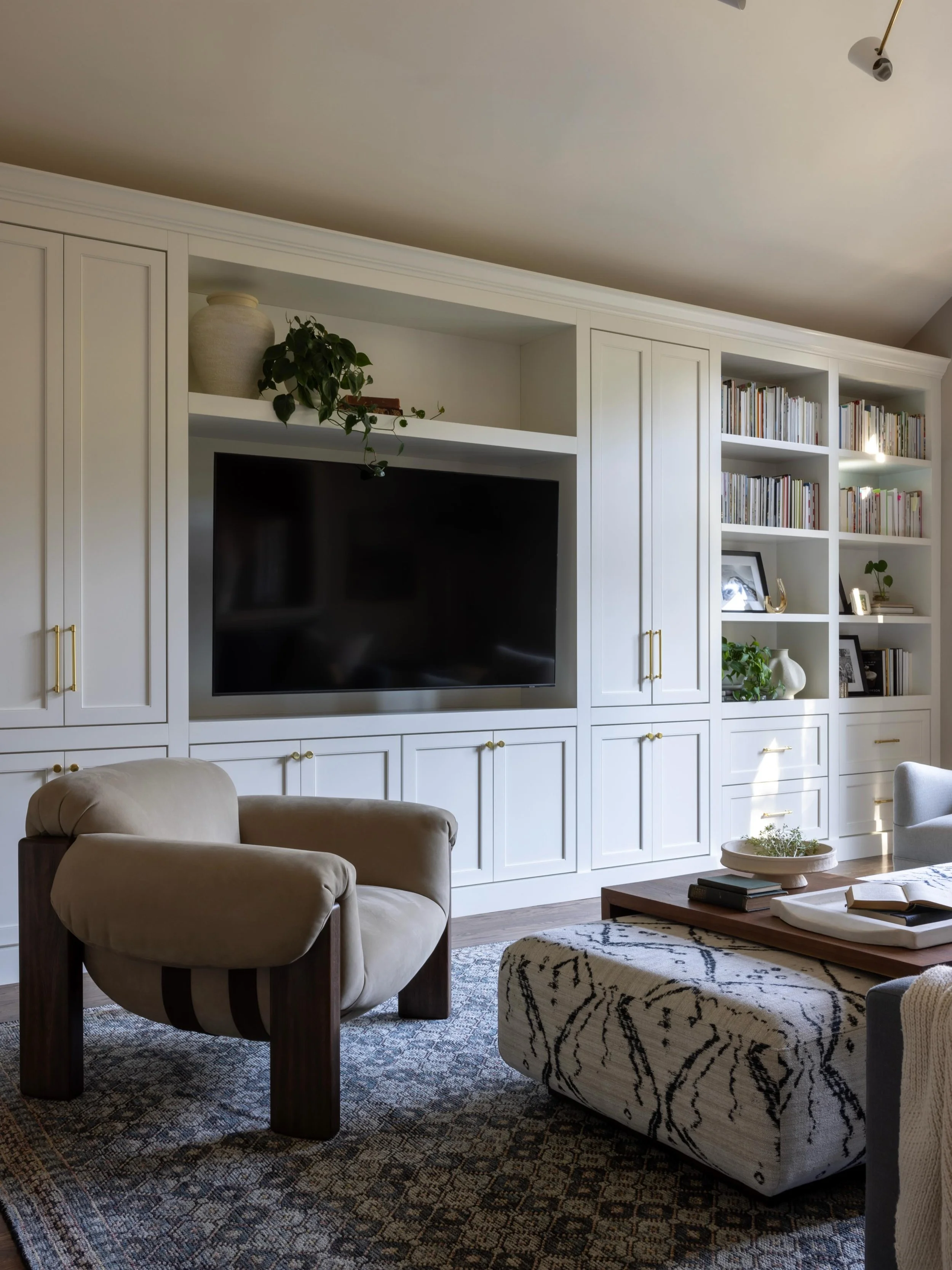 In this Family Room remodel, we removed the oversized fireplace and replaced it with a custom built-in, we reclaimed valuable square footage and created a quieter focal point. A new furniture layout with floating seating completely transformed the fl