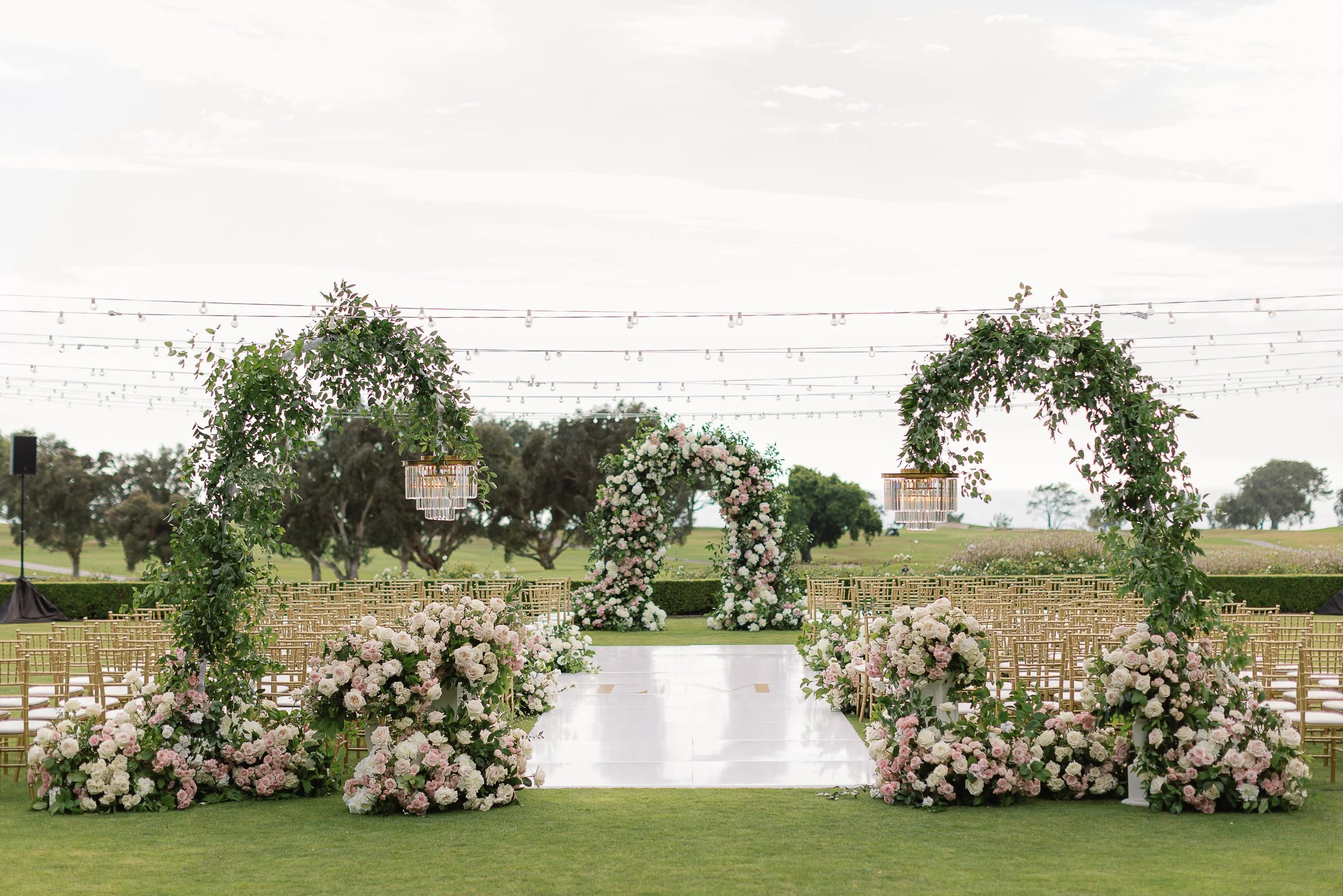 lodge-torrey-pines-wedding-floral-ceremony-arches-cafe-lights-daytime.jpg