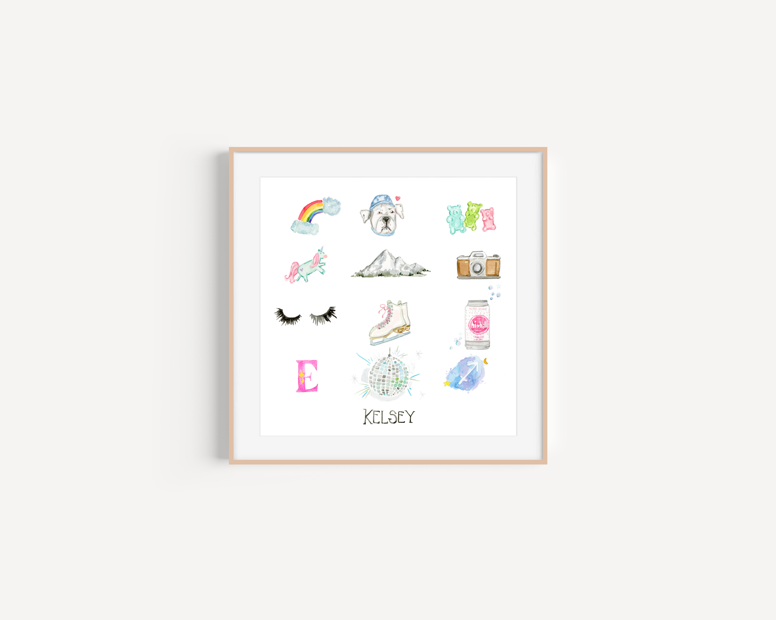 Decorative framed art with various pastel-colored illustrations including rainbow, bulldog, mountains, camera, eyelashes, roller skate, drink, disco ball, perfume, and a pink letter E, with the name 'Kelsey' at the bottom.
