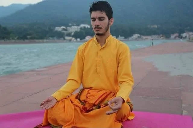 Manohar as a young student in Parmartha Gurukul, practicing breathing awareness at Ganga ghat.
