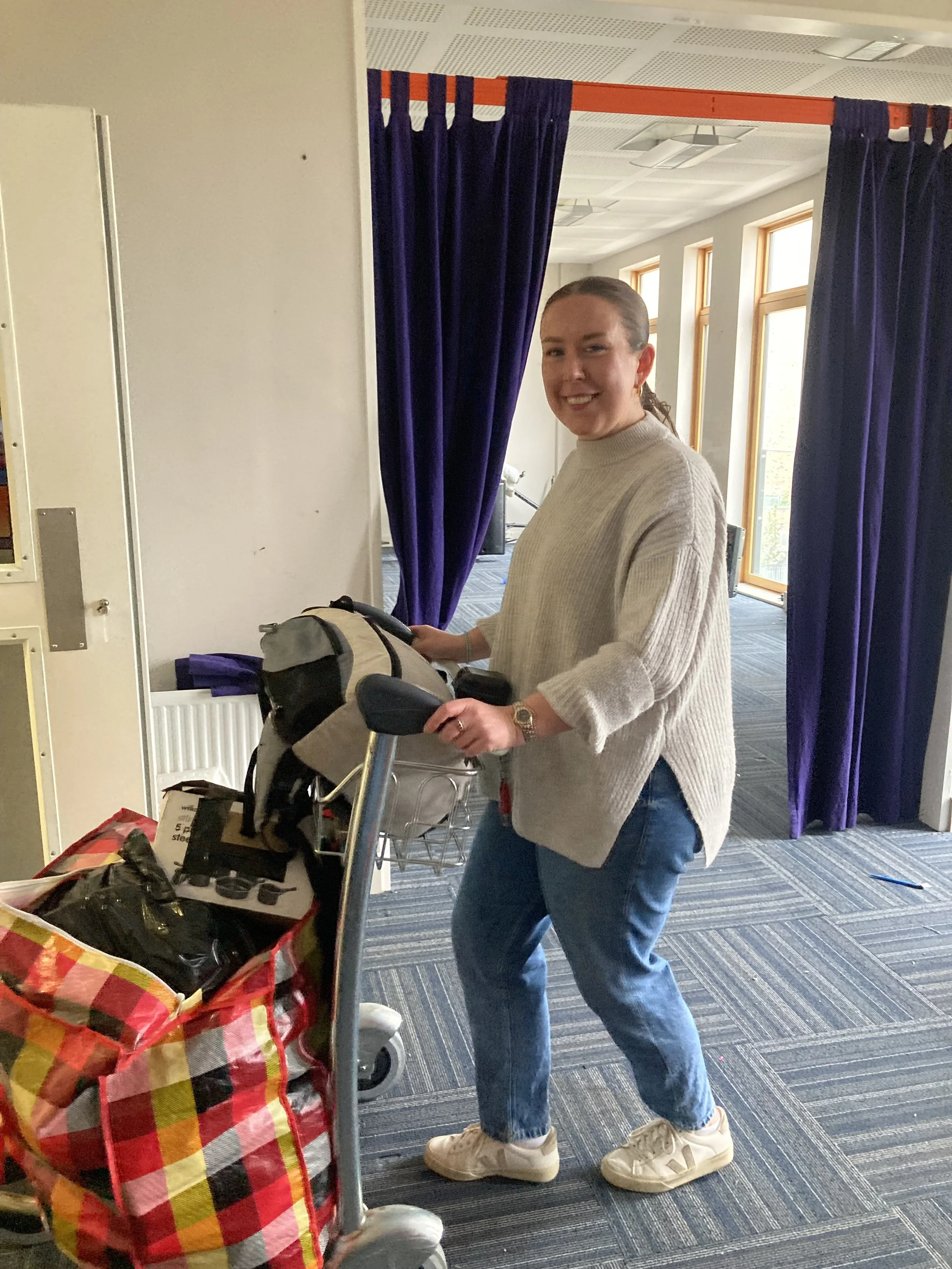 Volunteer moving belongings on a trolly.