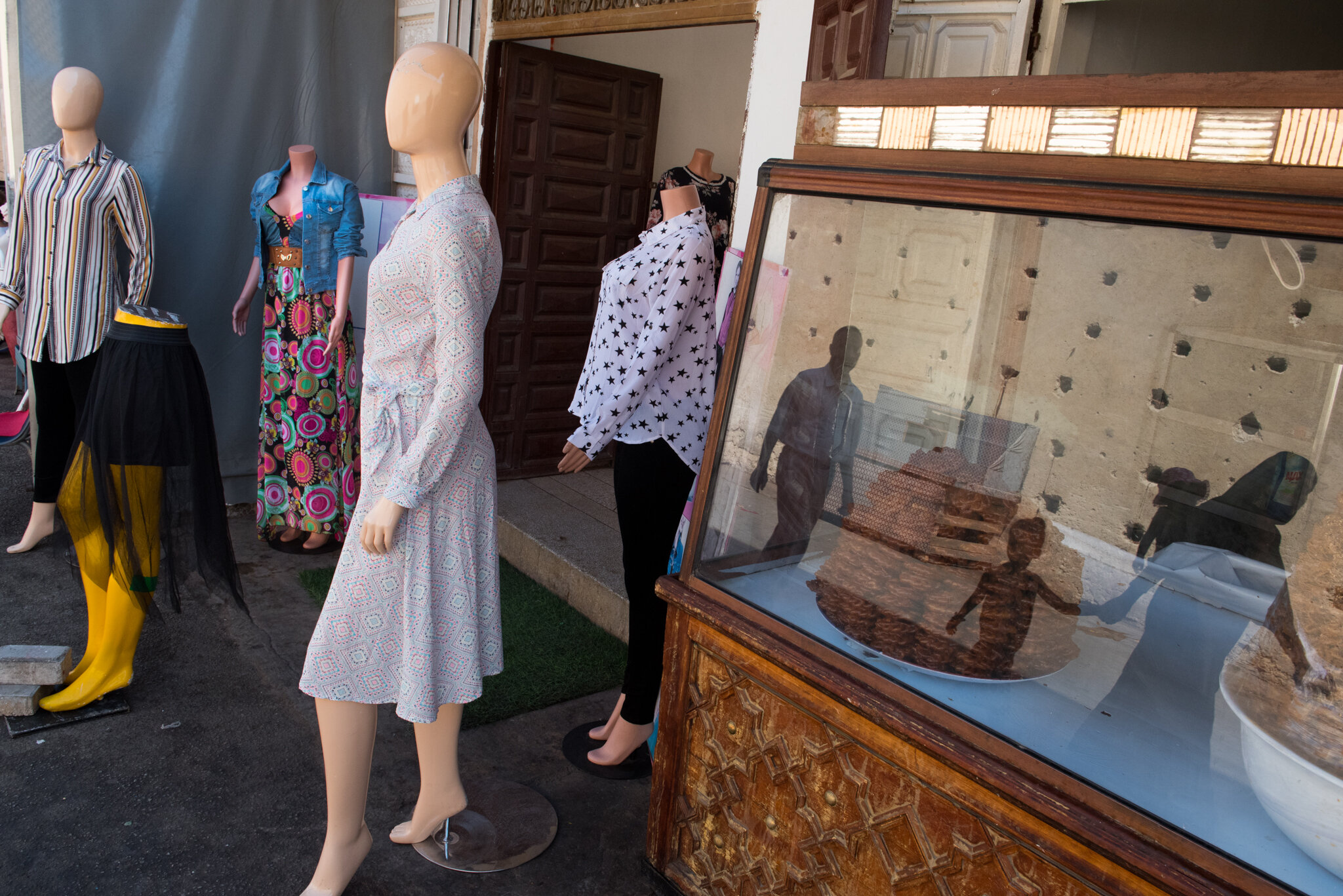    Morocco - Fes      Reflection in pastry vitrine. Woman carrying baby. 