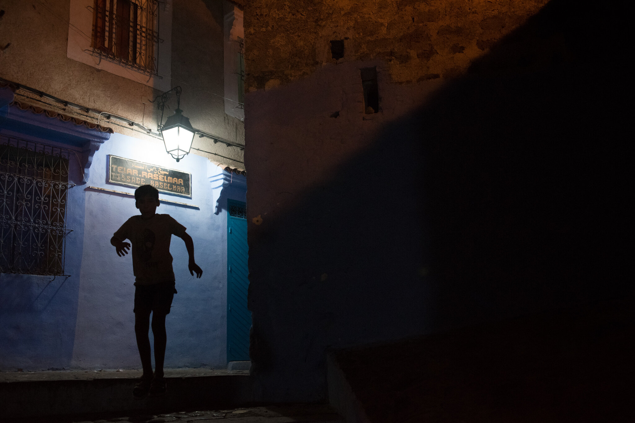   Morocco - Chefchaouen     Boy running through old medina streets at night 