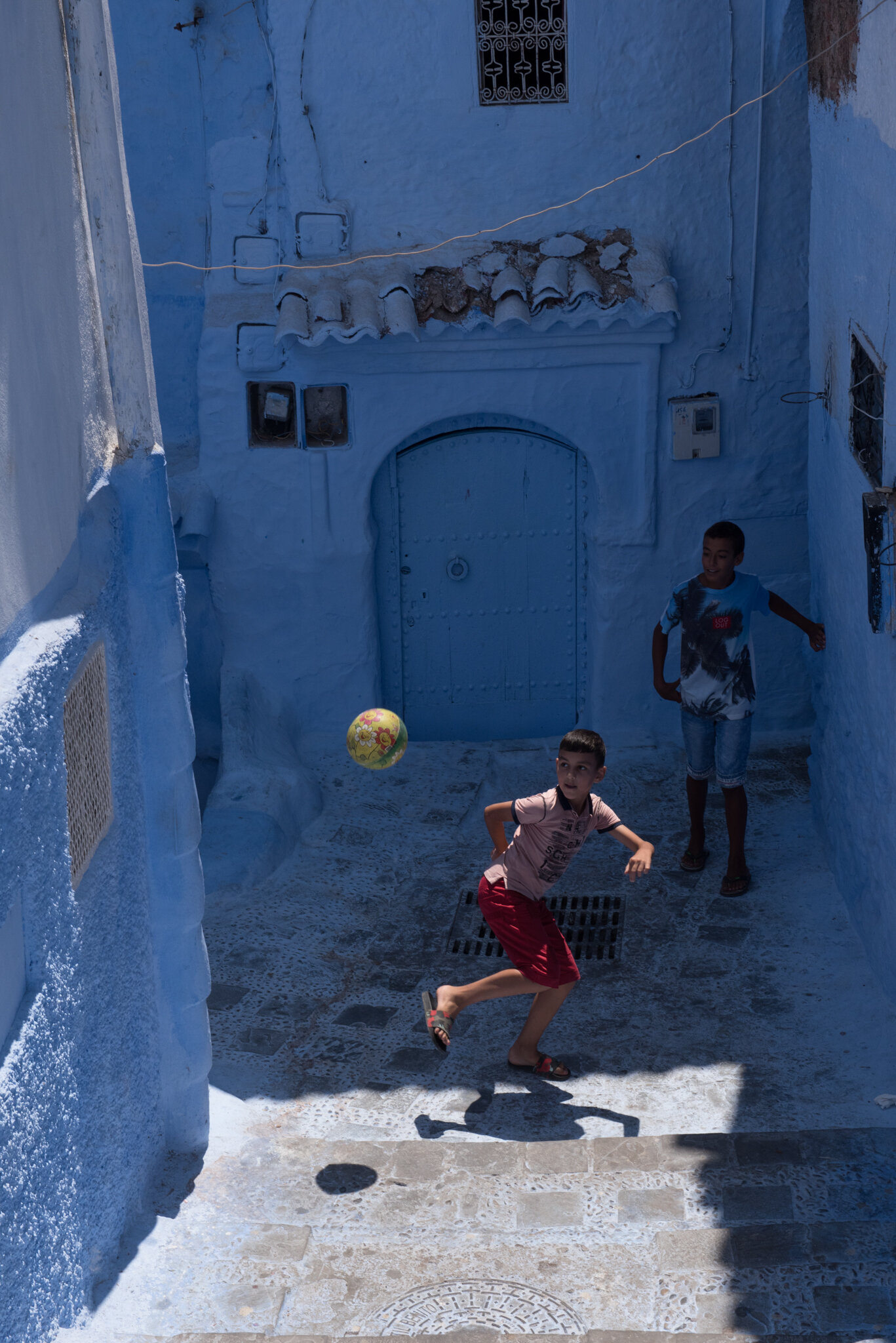    Morocco - Chefchaouen      Boys playing soccer in alleyway 