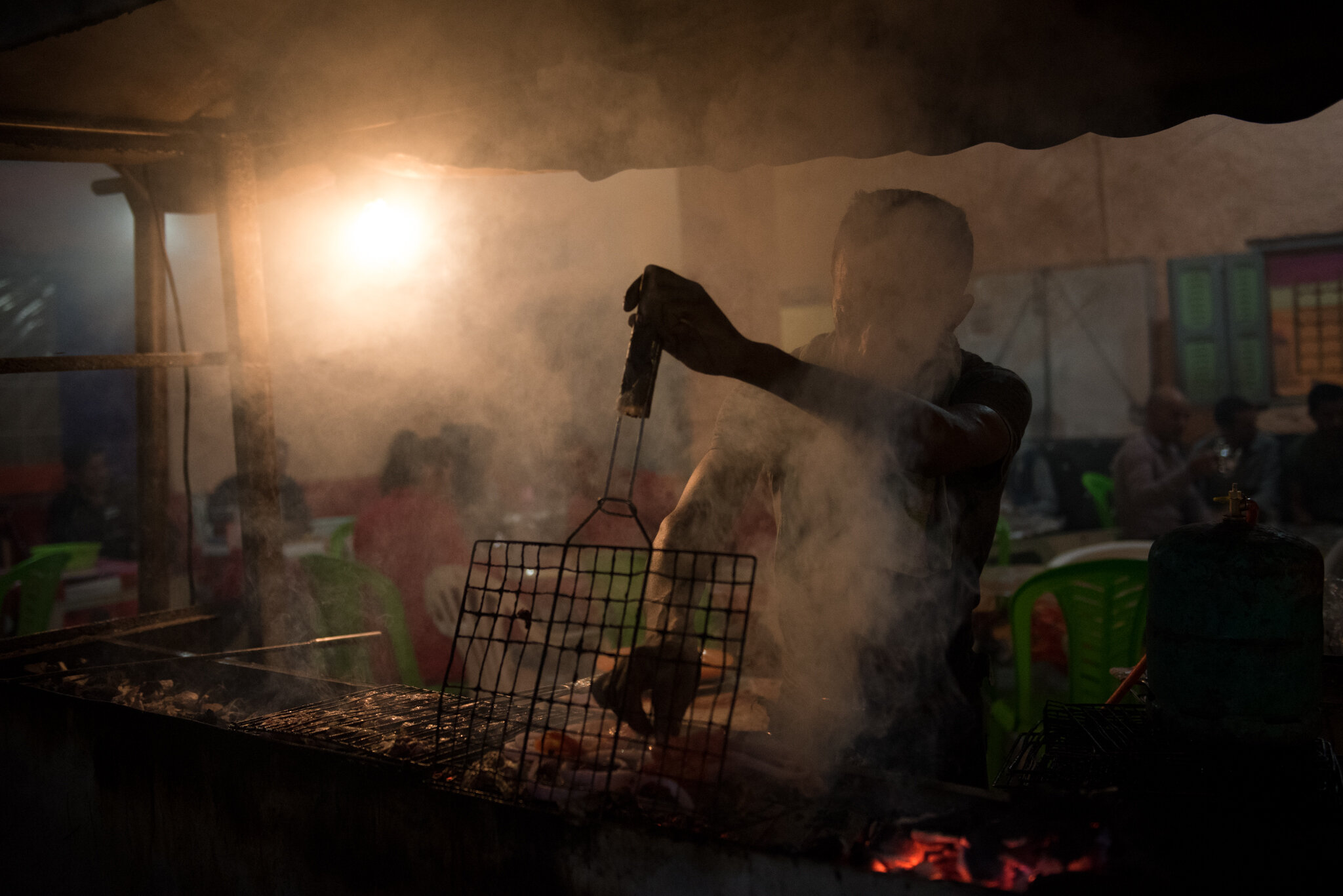    Morocco - Imilchil      Man grilling lamb at night. Local cafe 