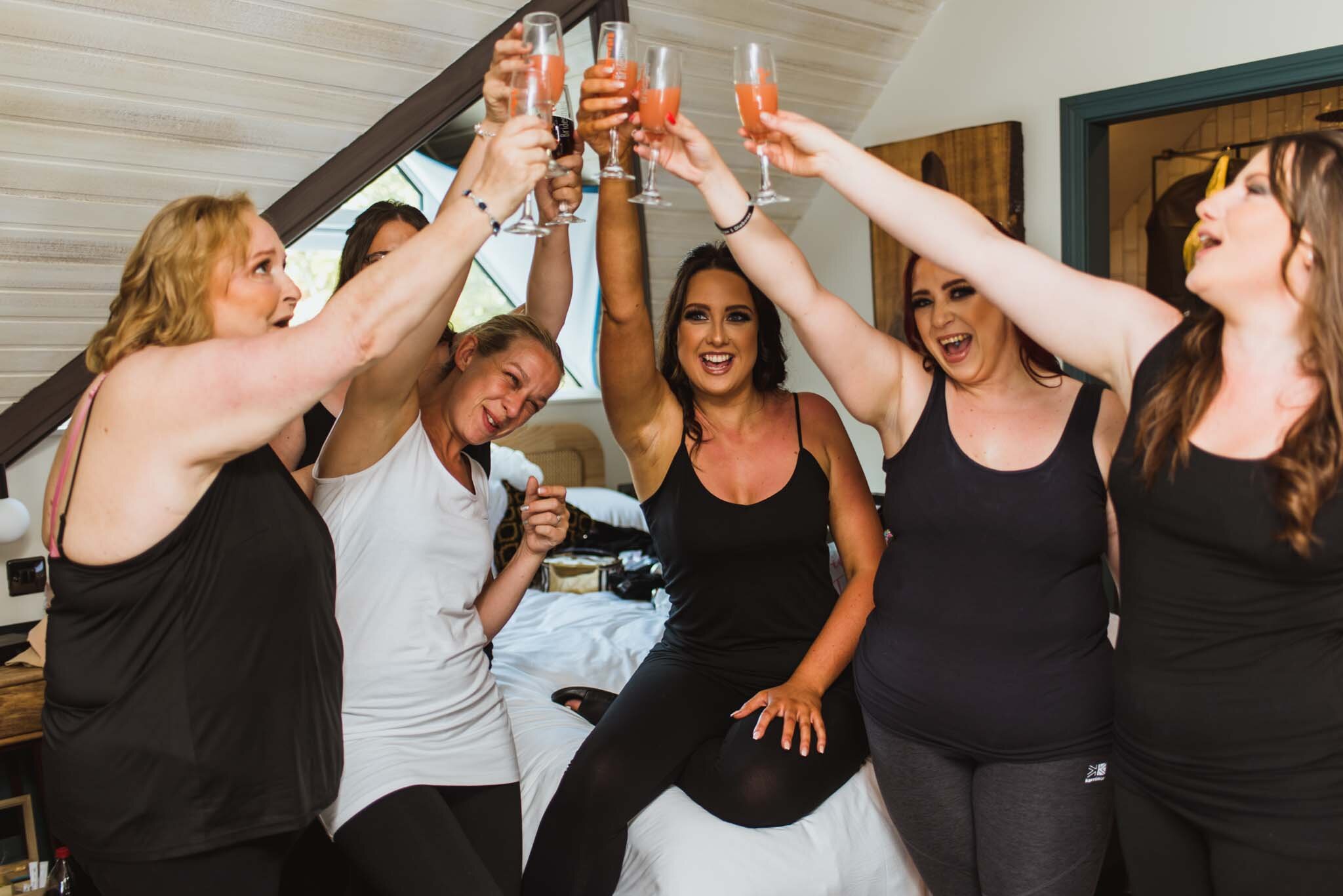  Cheers after bridal preparations in the hotel room. as the girls toast. 