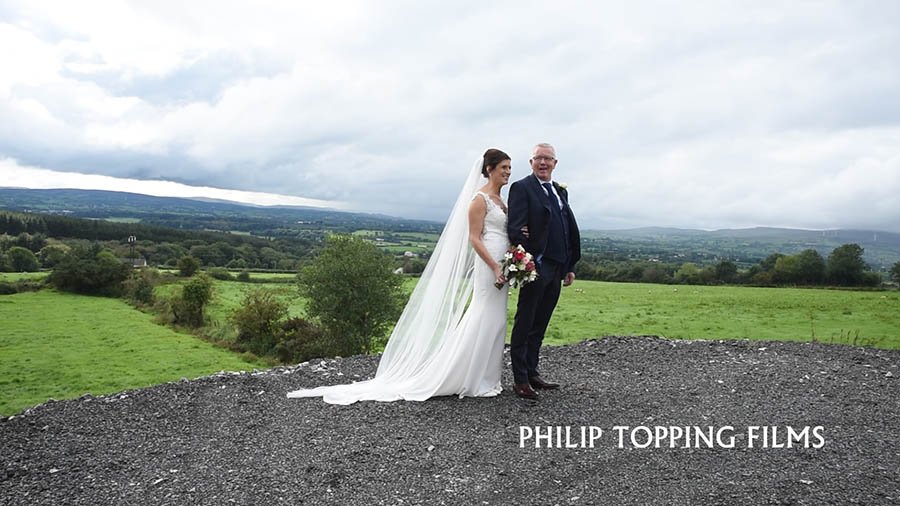  Bride and groom portrait in countryside  with green fields and trees in distance in Omagh. 