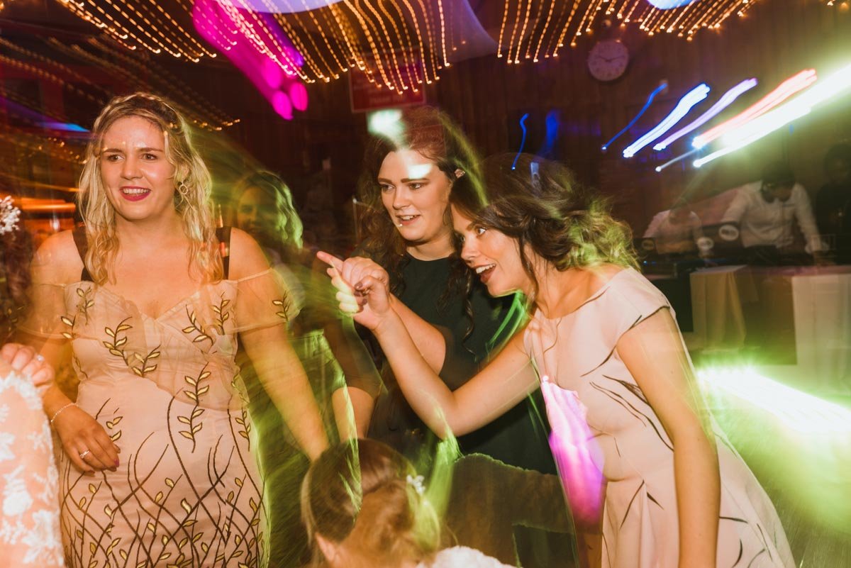  Three guests partying and dancing with Music Matters playing as the DJ.  Colourful image captured using a slow shutter speed. 