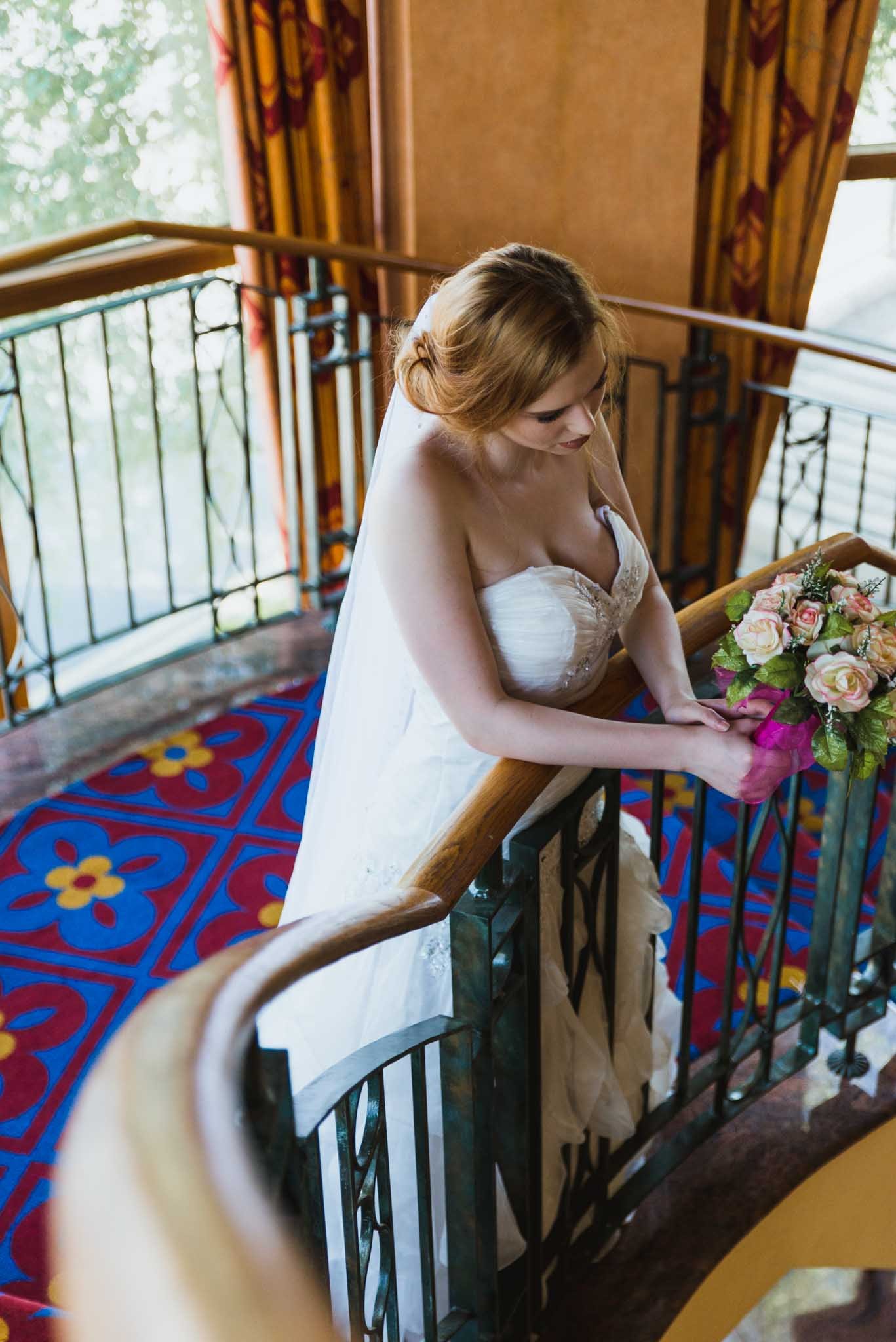  A great wedding venue in Portadown is the Seagoe Hotel as the bride leans over railings inside. 
