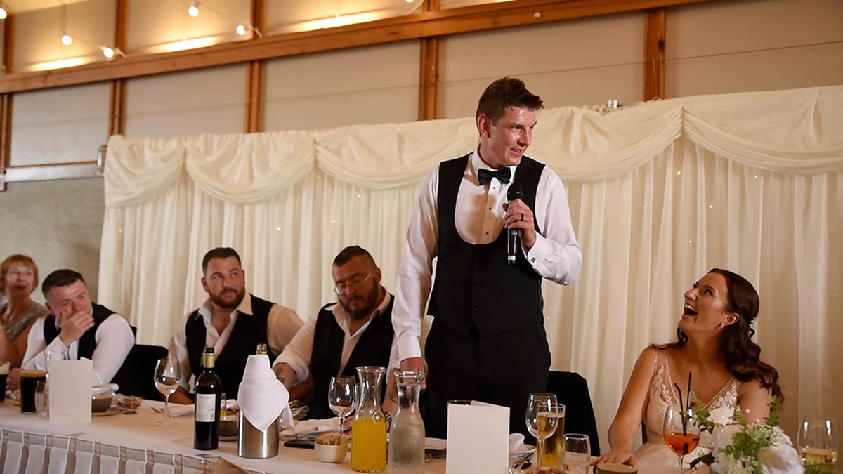  Groom making speech at long table in Reception 