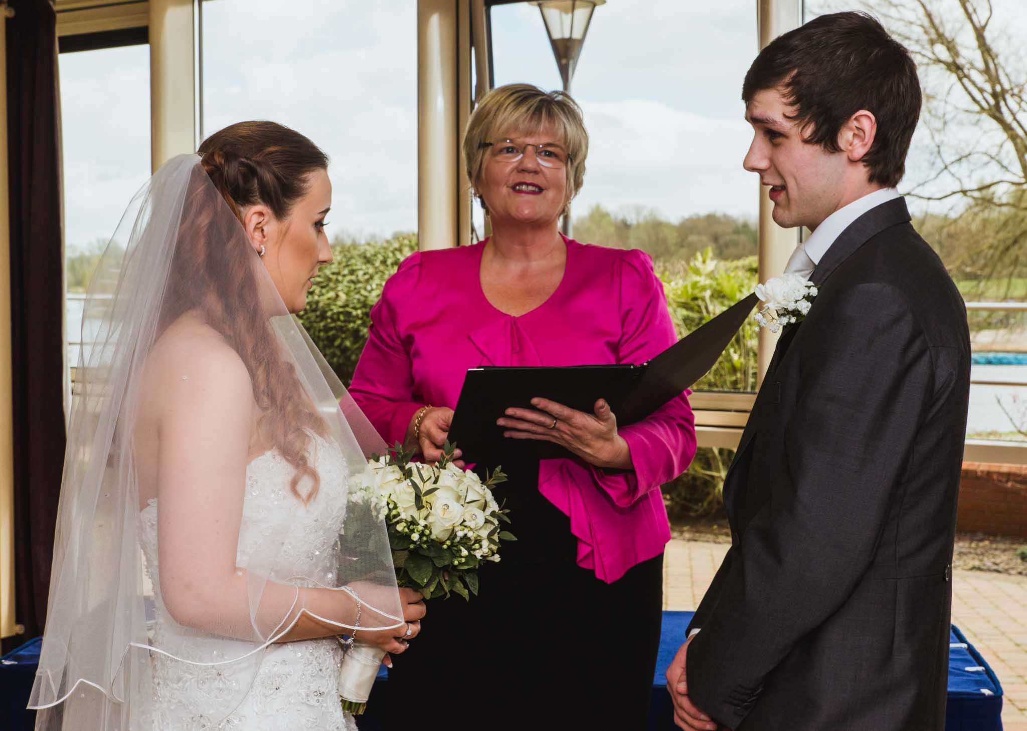  Ceremony in Craigavon Civic Centre with bride and groom in foreground and registrar in middle. 