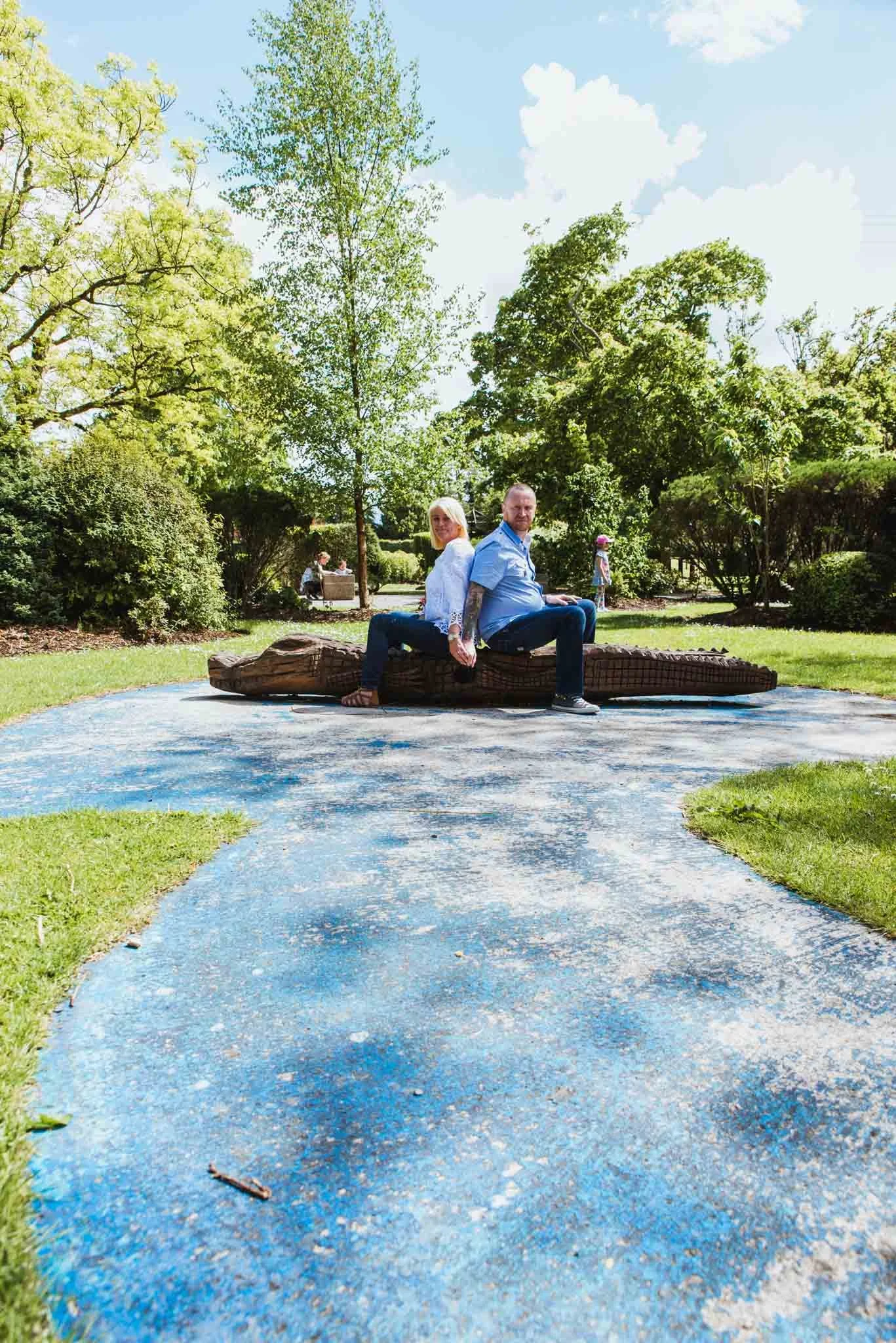  Path leading up the two sitting on wooden crocodile with plenty of greenery around them 