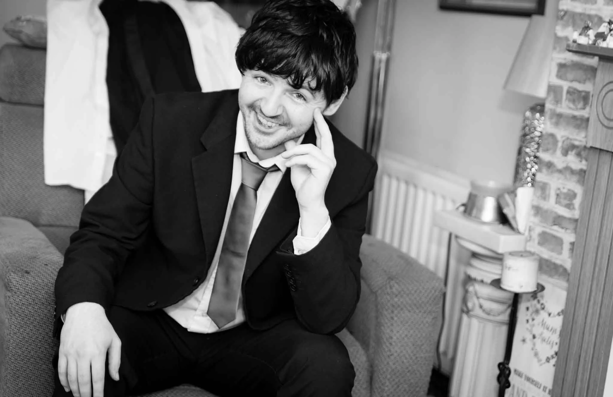 Groomsmen sitting smiling at the camera, just a bit camera-shy.