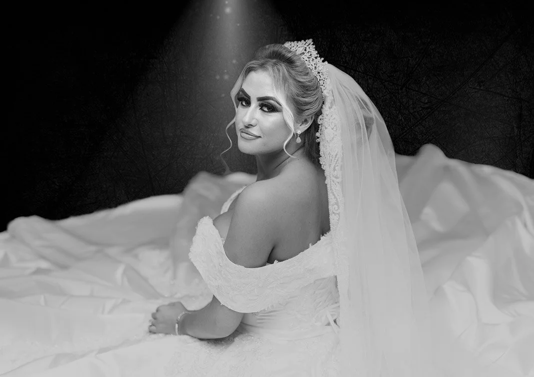 Bride sitting around dress for a portrait in mono.