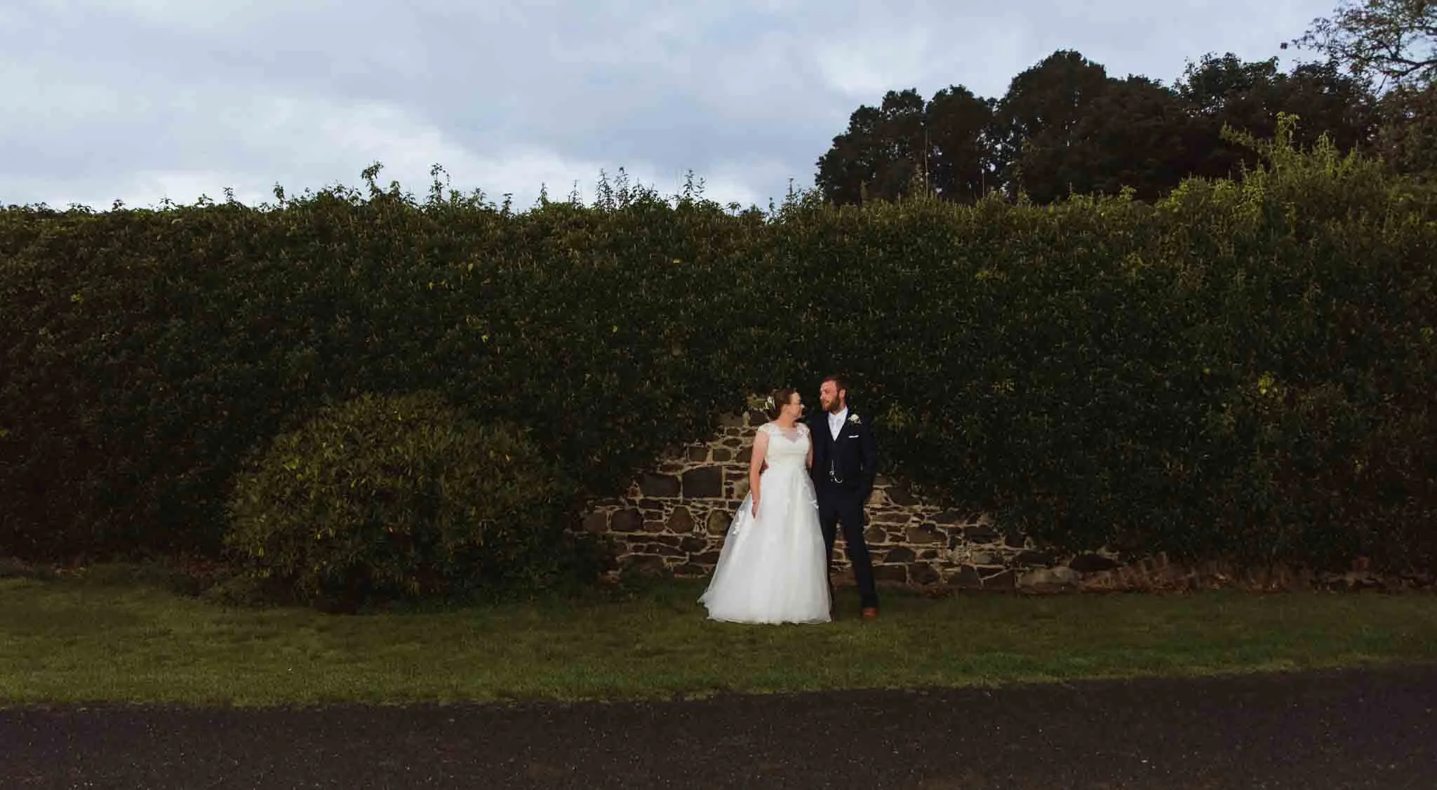 Portadown Golf Club wedding with the bride and groom in front of an ivy wall.
