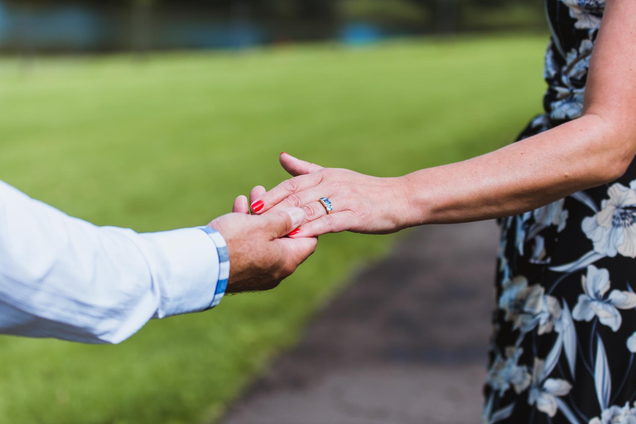 Male holds females hand as they just got engaged.