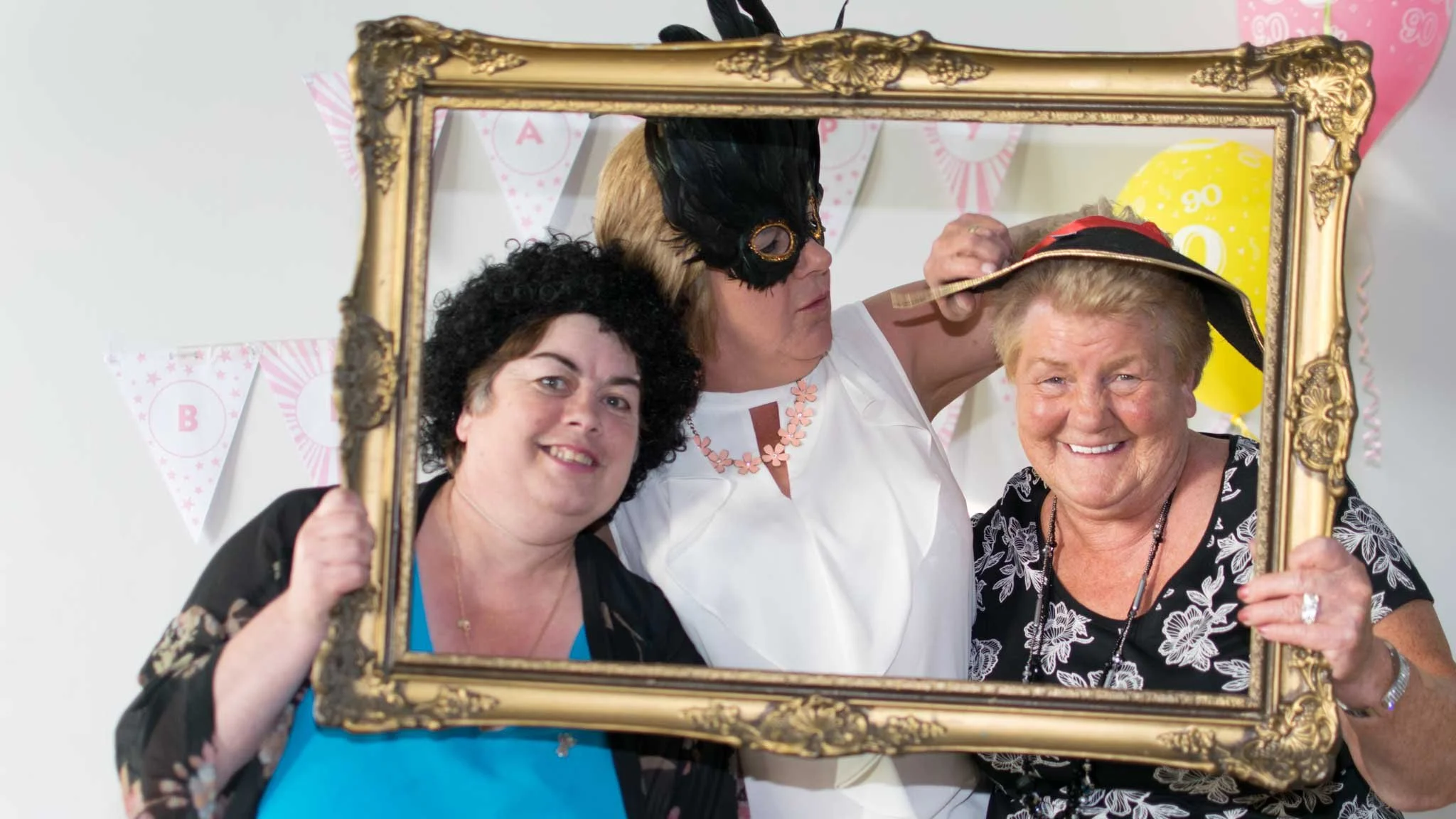 People having fun with a golden frame posing for a photo.