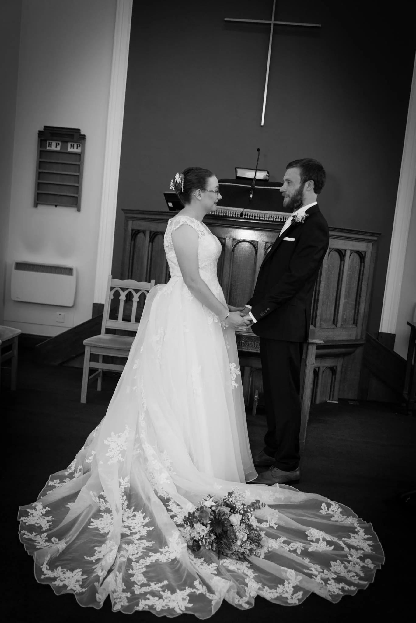 Standing looking at eachother holding hands in black and white.