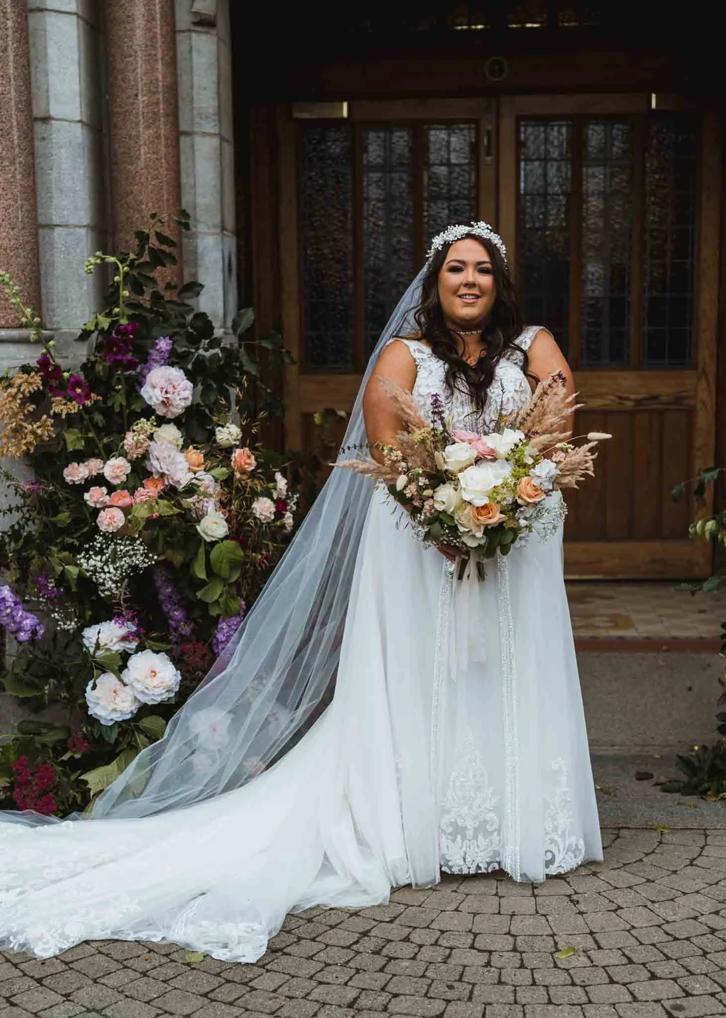 Bride with bouquet at the entrance.