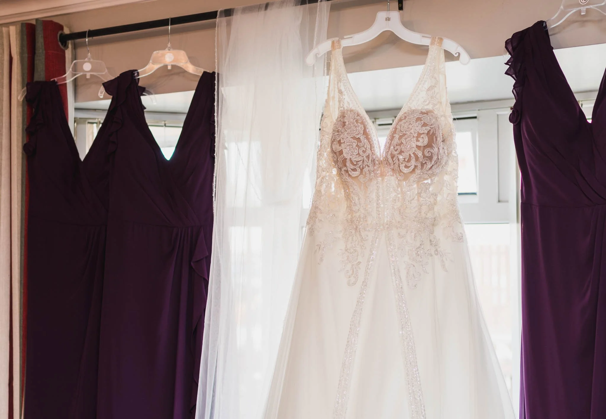 Dresses hanging up in the living room window.