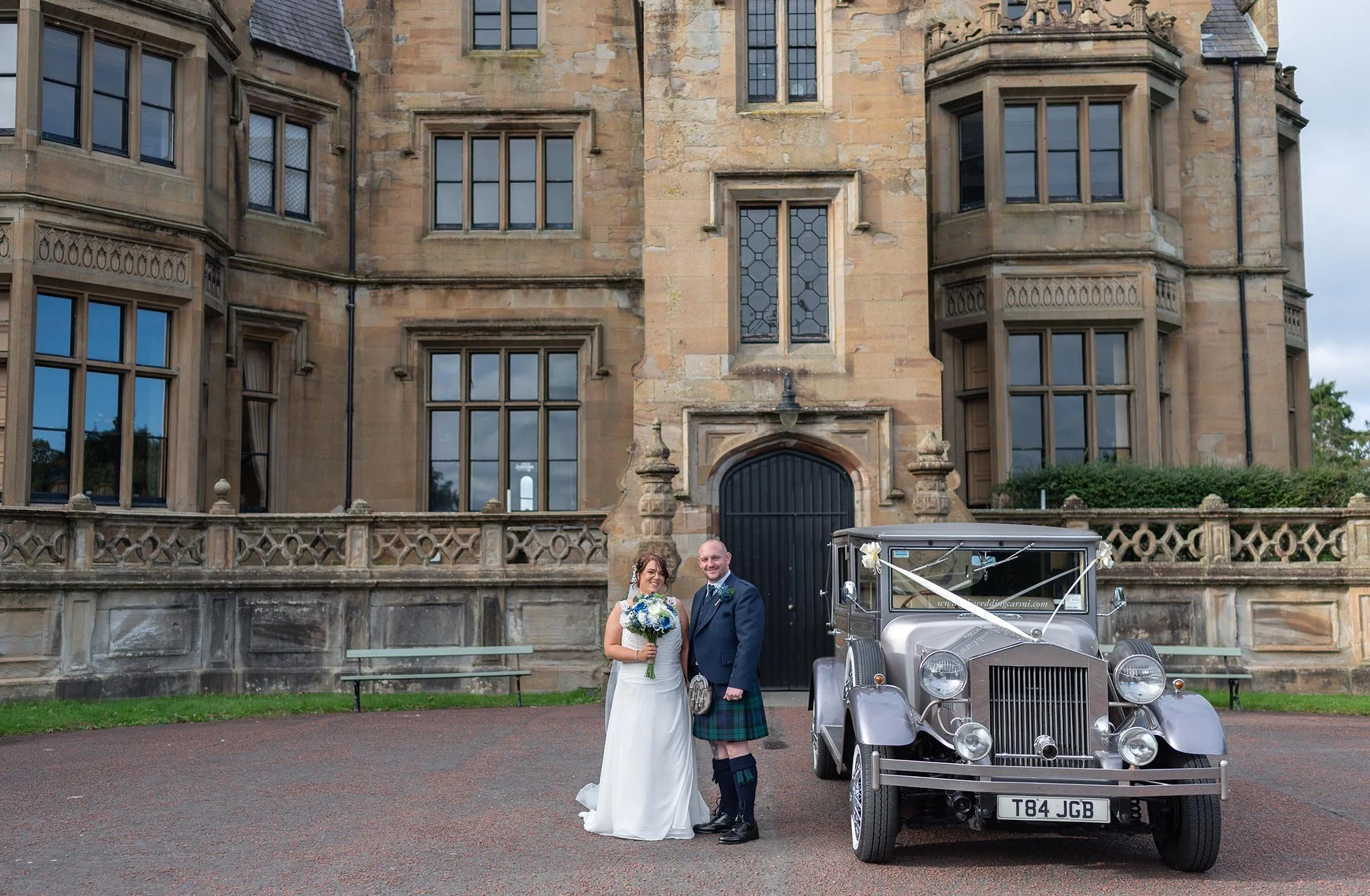 Bride and groom beside the limo outside Brownlow House.