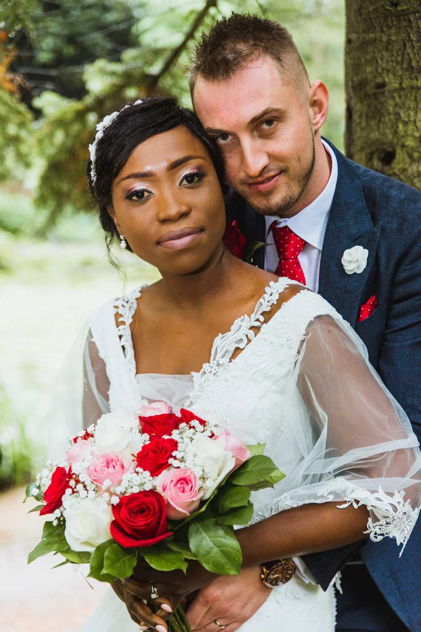 Close-up photo of the male's head touching females head as they both look at the camera for a portrait.