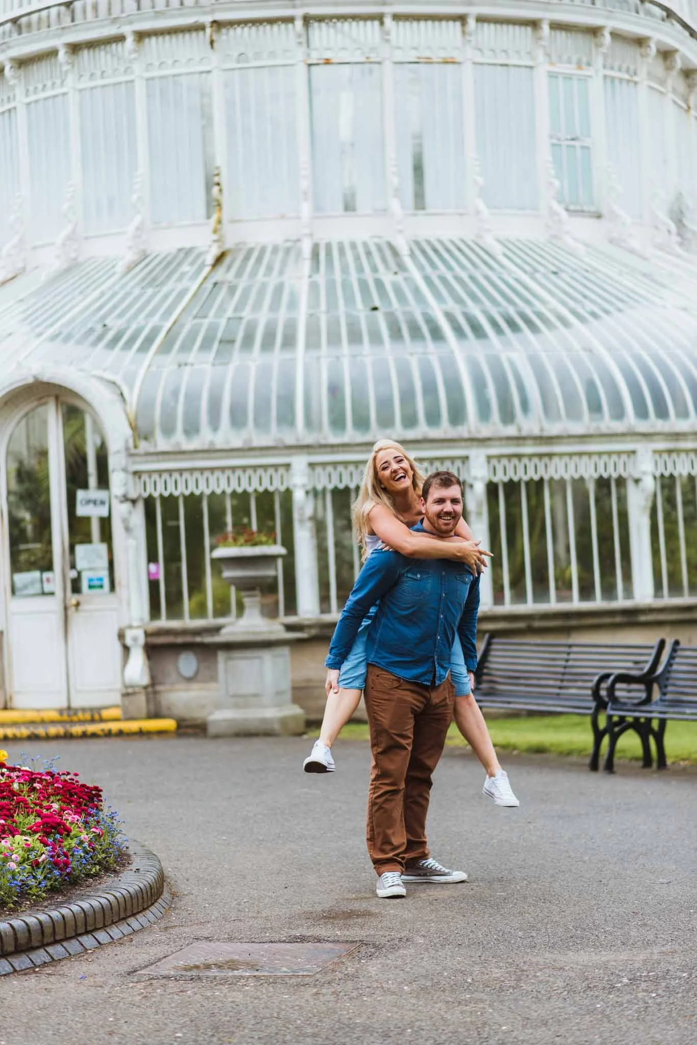 A male gives a female a piggyback ride in front of the Palm House.