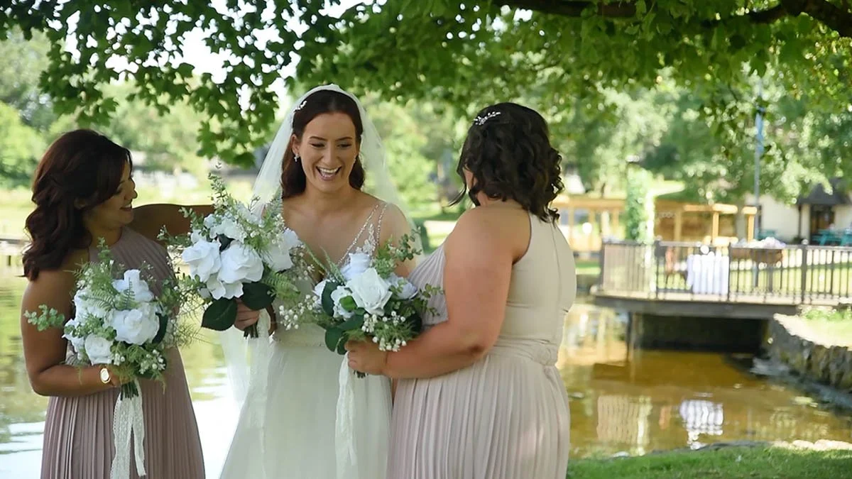 The bride with bridesmaids outside in the bright weather.