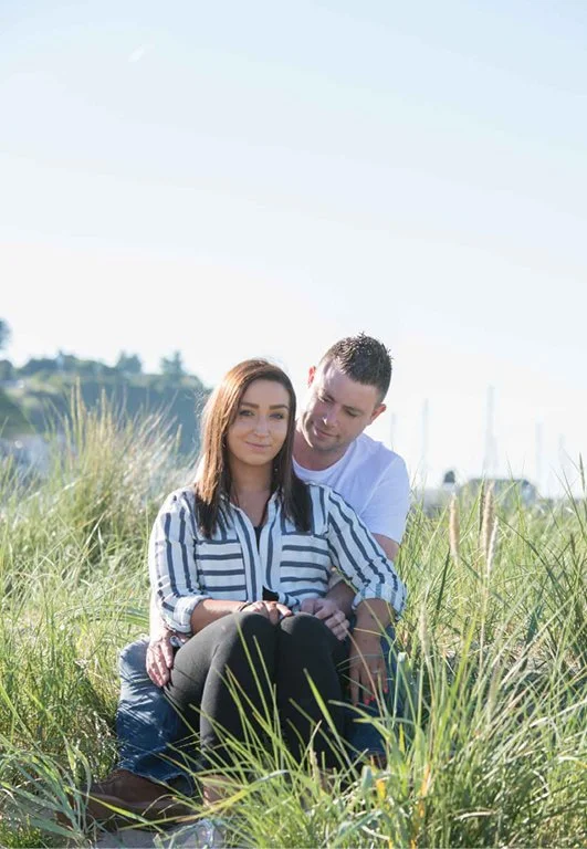 A couple sitting beside each other at the beach.