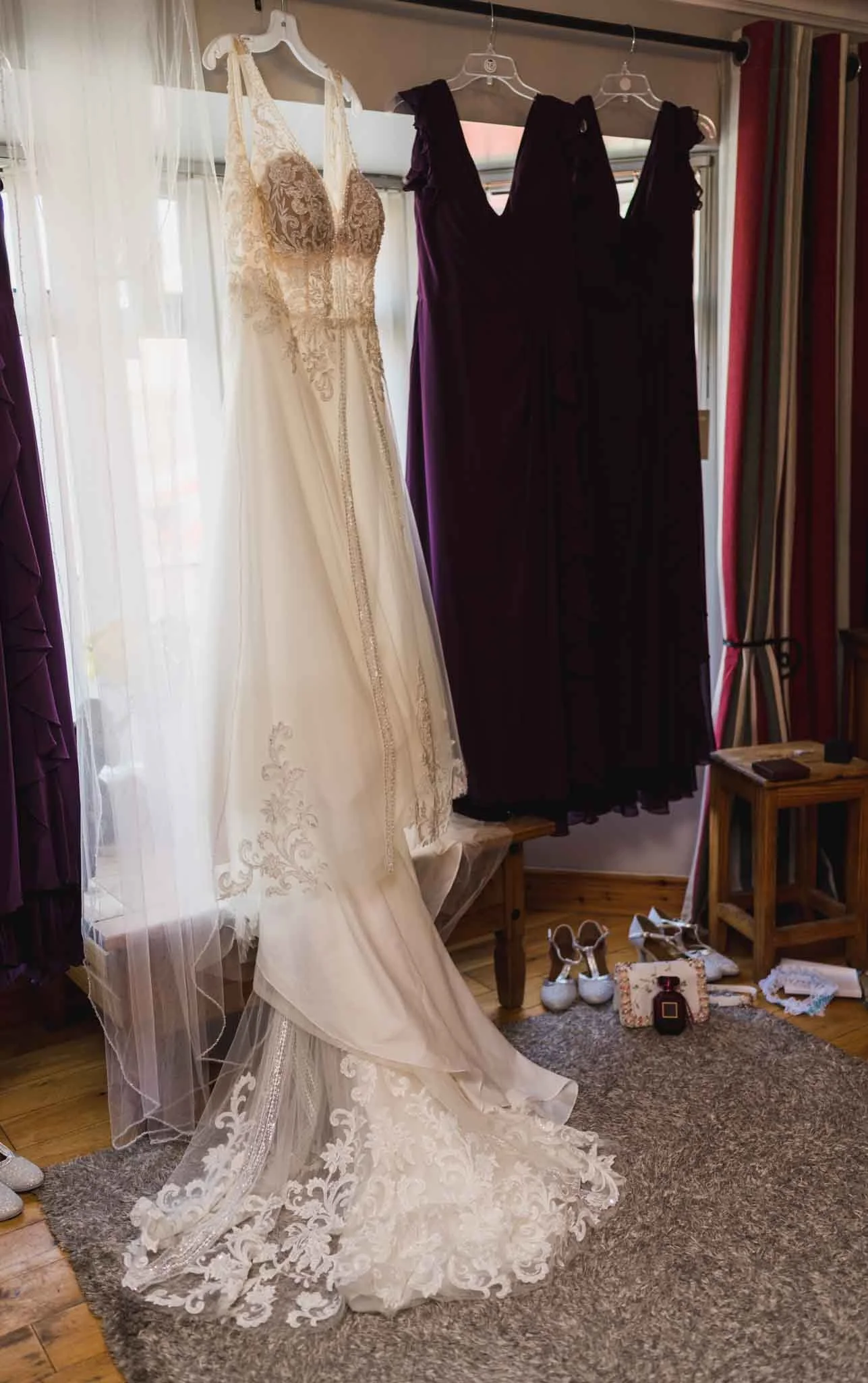 Wide photo of the dresses hanging up at the window.