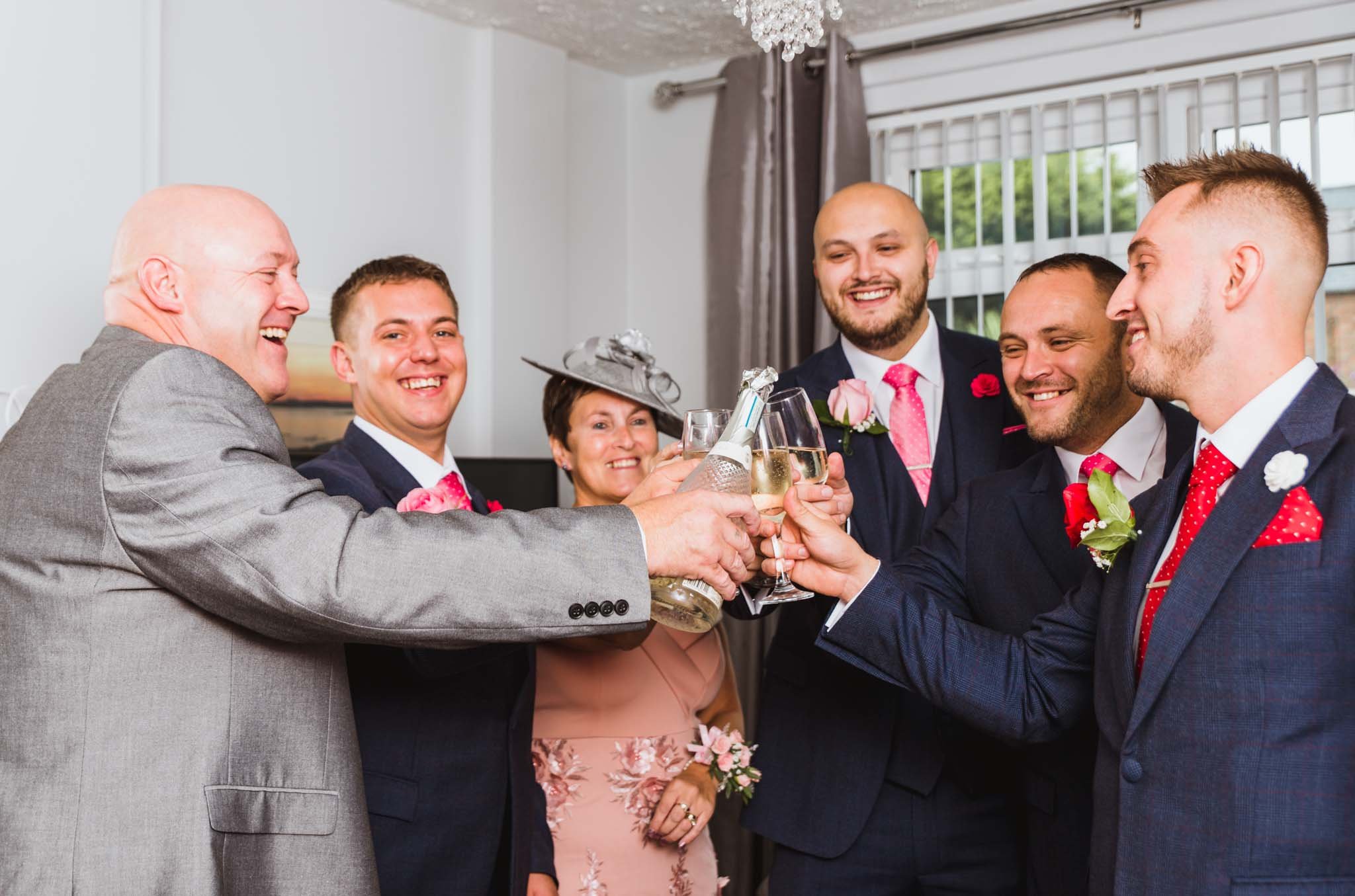 The groom with parents and groomsmen toasting champagne to the day.