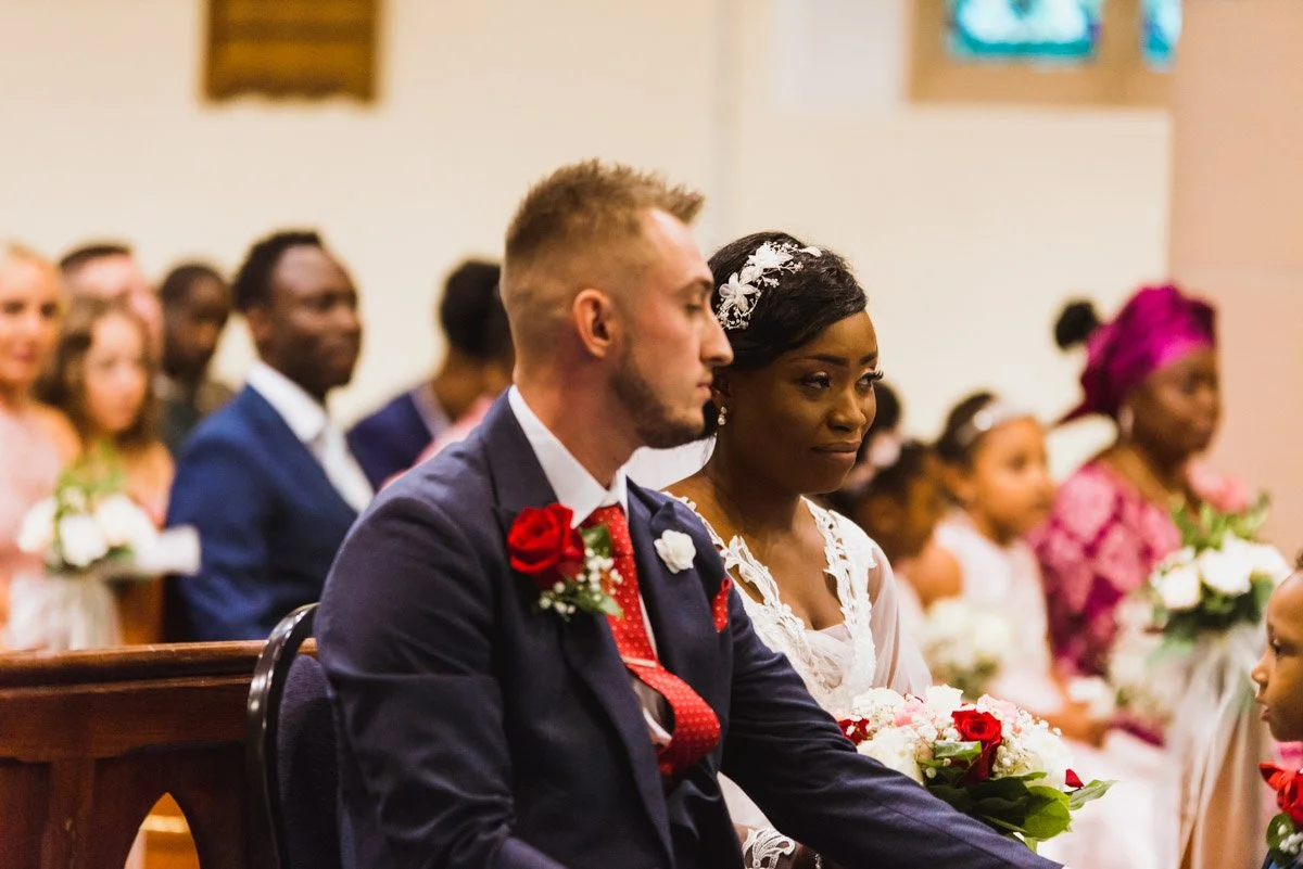 Mixed race couple as bride and groom sit and listen to the ceremony.