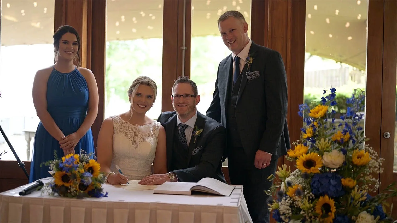 Bride sitting beside the groom with the bridal party after signing inside.