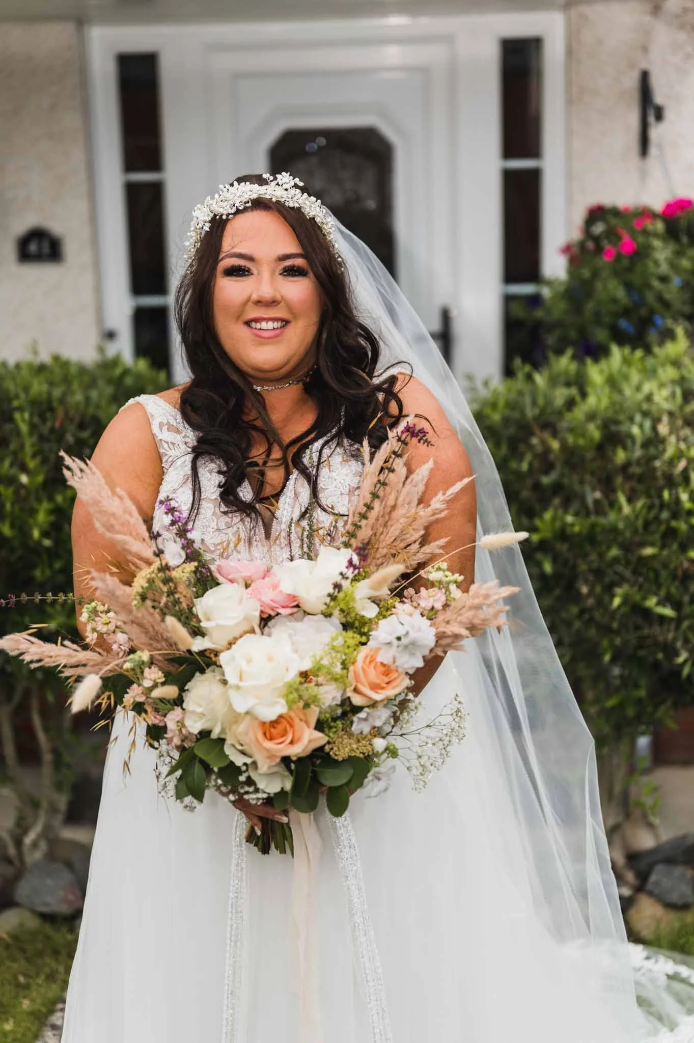 The bride with a bouquet outside the family house in Portland Manor.