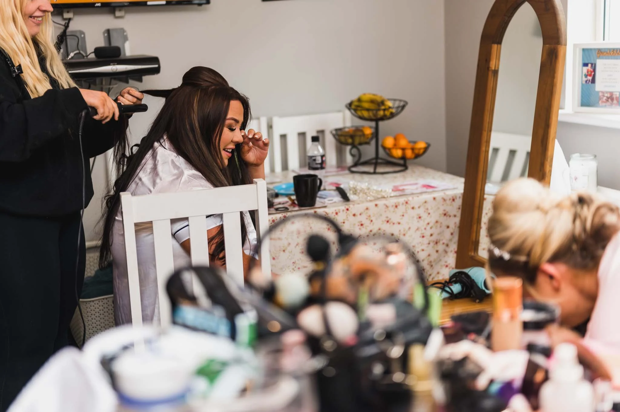 Bride getting hair done in the kitchen, crying with tears of joy at the bridal preparations photography.