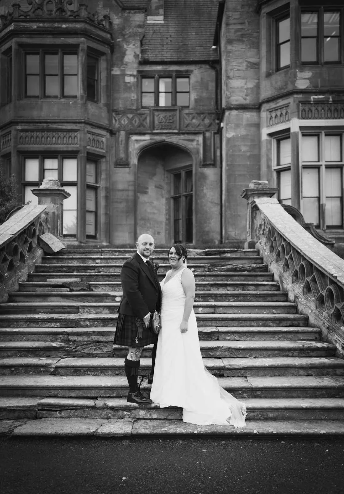 Bride and groom on the steps of Brownlow House in Lurgan in monochrome and black and white.