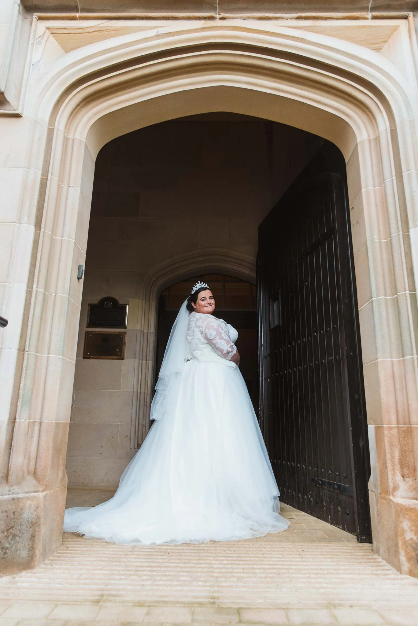 Bride at the entrance of the building showing the beautiful structure of the castle.