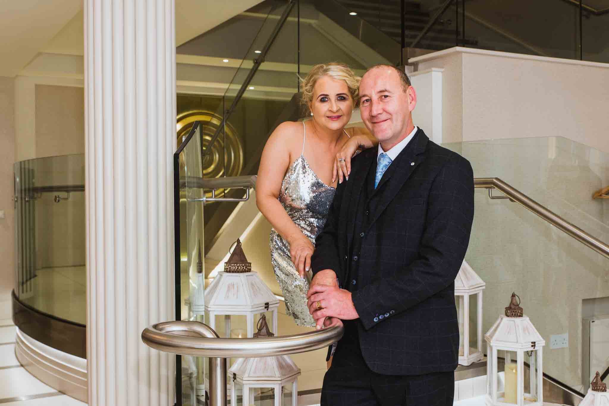 The bride and groom are beside each other in the foyer.