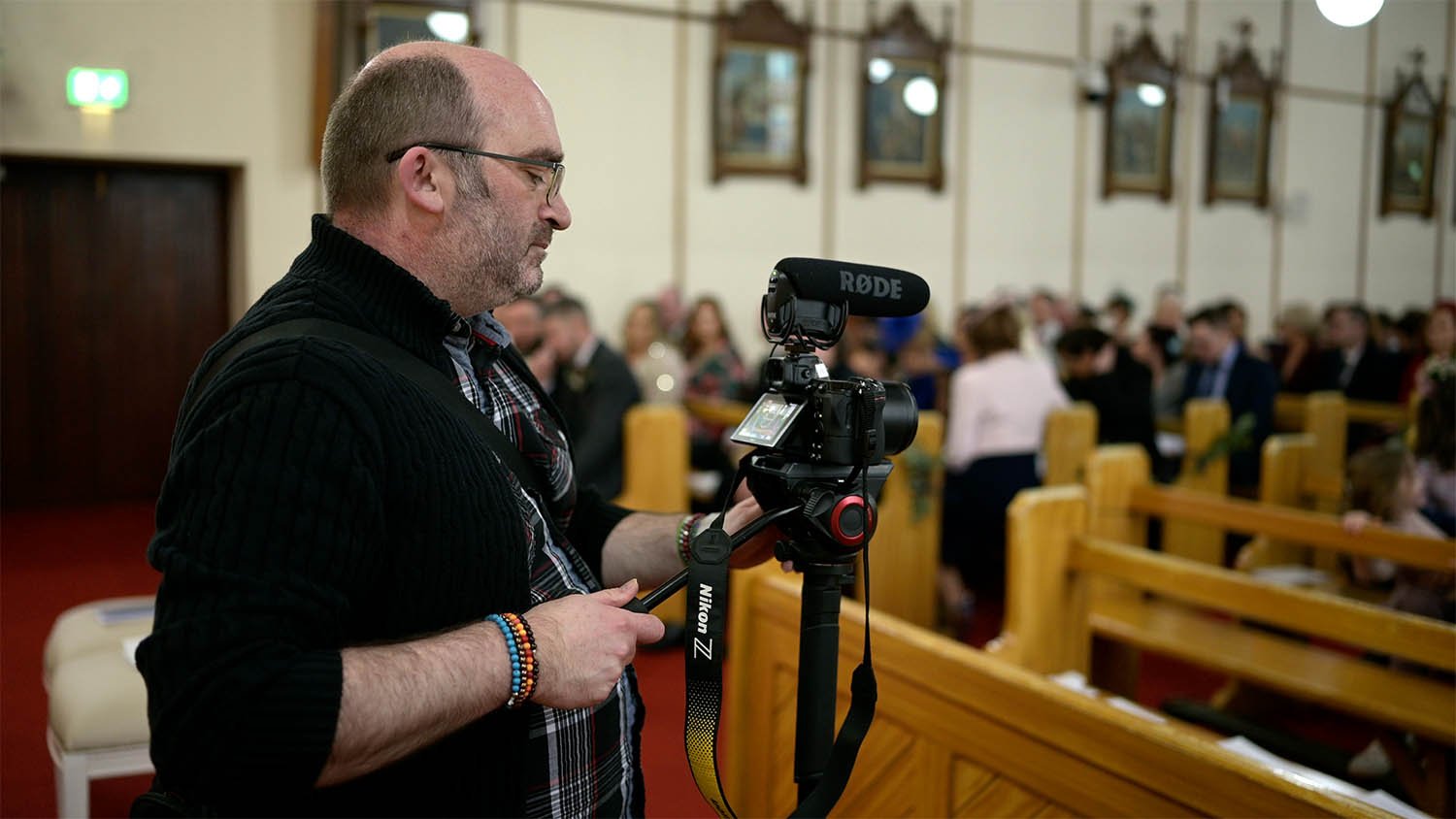 This is a behind-the-scenes video of a wedding videographer in Portadown, filming as guests take their seats.