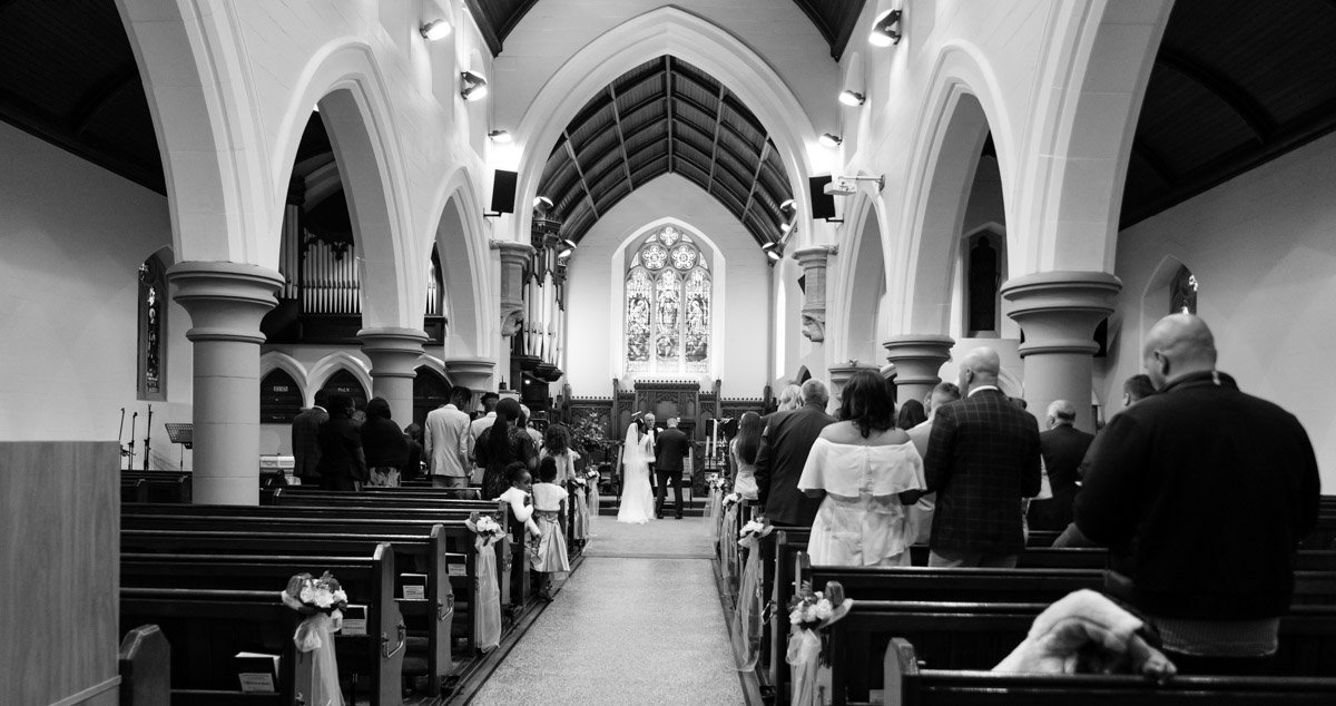 Mono image photographed from the back of the room showing large pillars.