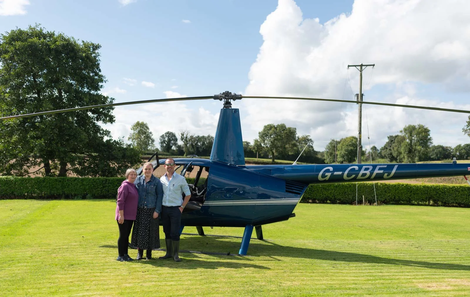 The male's partner and mother are beside the helicopter.