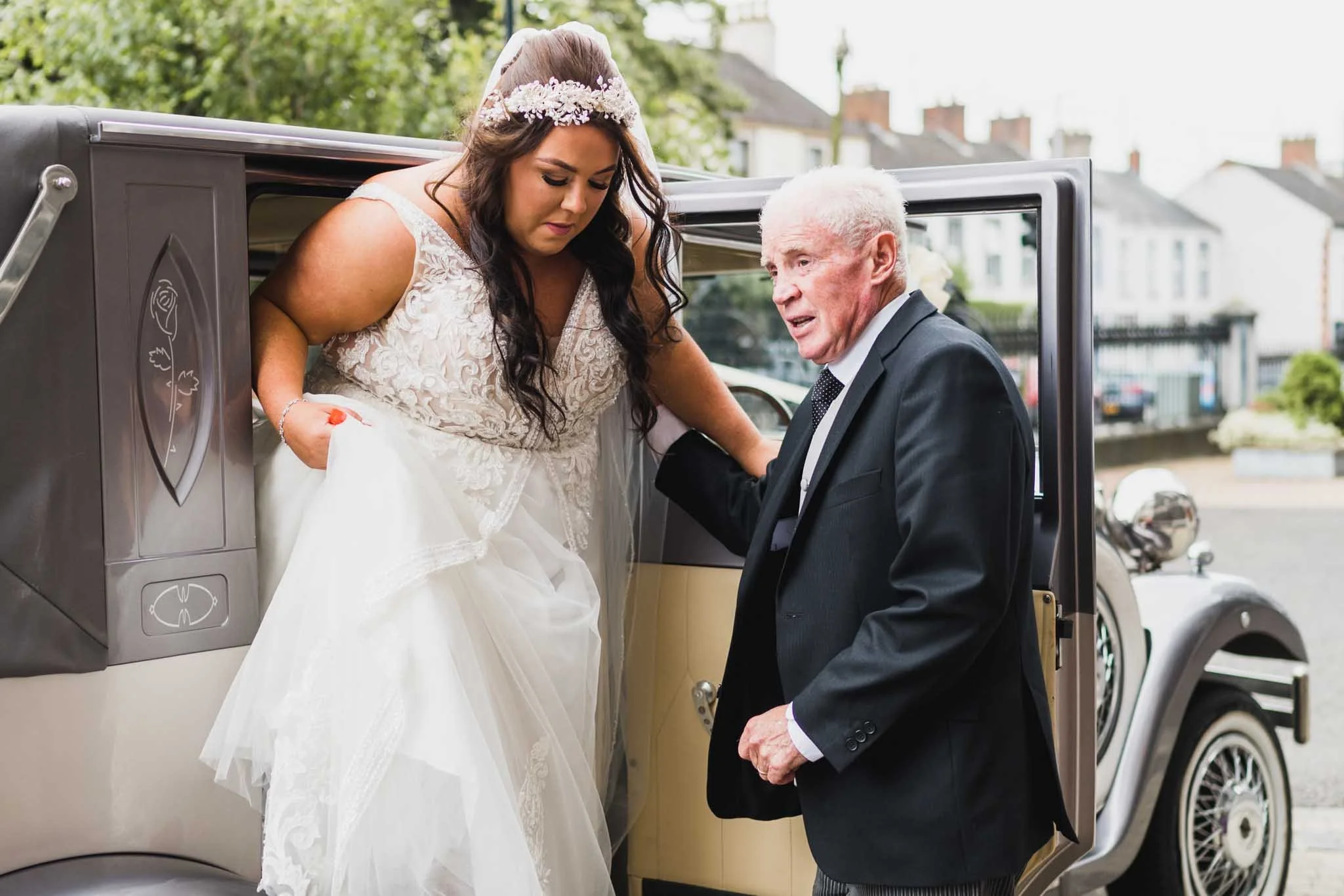 Bride getting out of the limo with the driver helping.