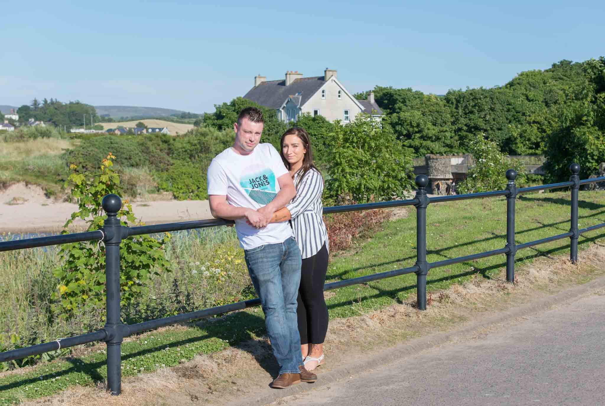 A couple is beside each other beside the railing.