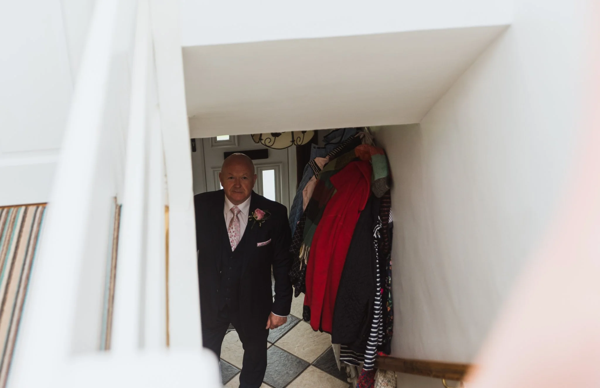 Father of the bride looking up at the stairs.