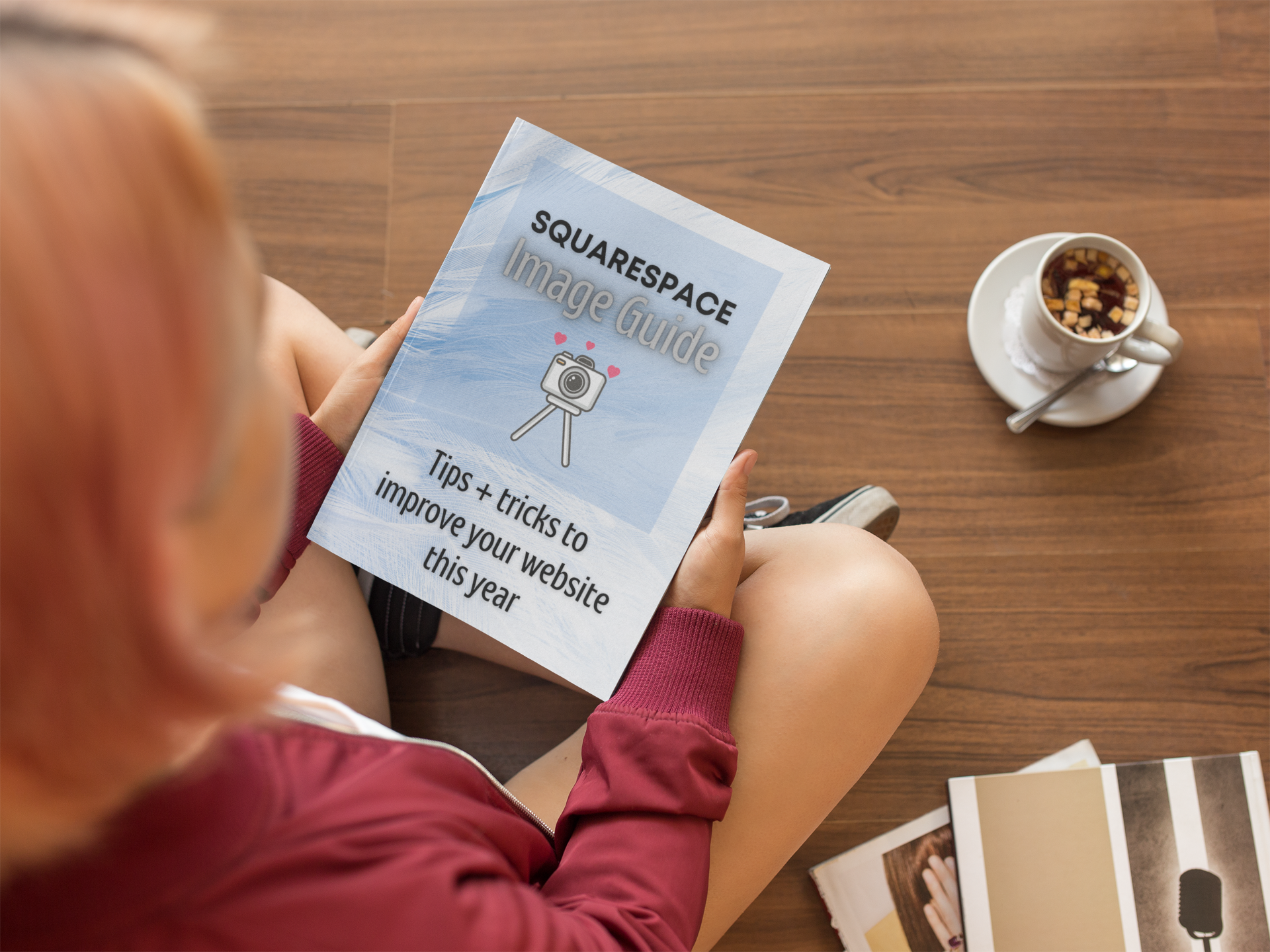 mockup-of-a-girl-holding-a-book-while-sitting-down-on-a-wooden-floor-a14364.png
