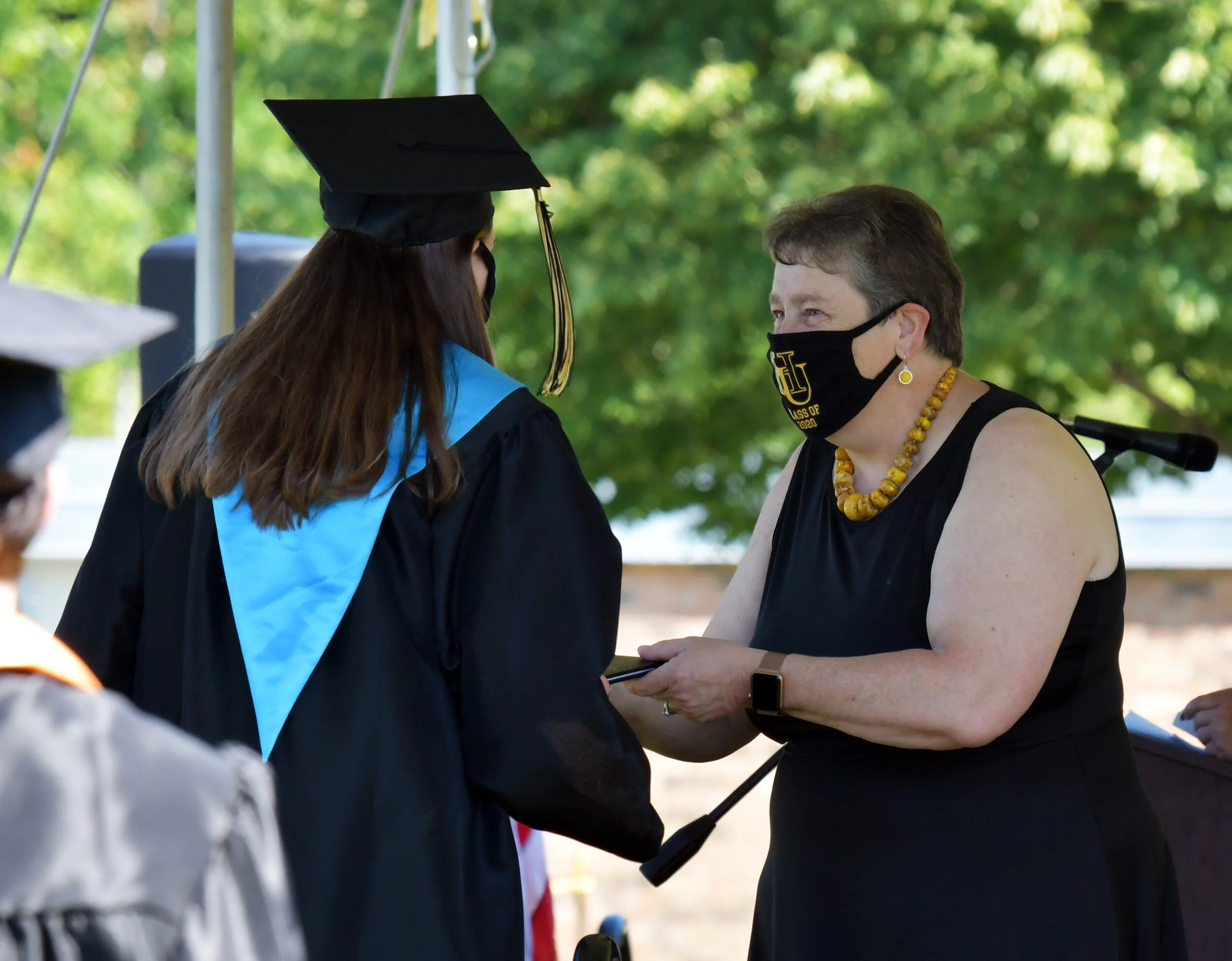A graduation first: Principal Lisa Atwood, students and staff participating in commencement all had HU face masks for the occasion. Photo by Gordon Miller.