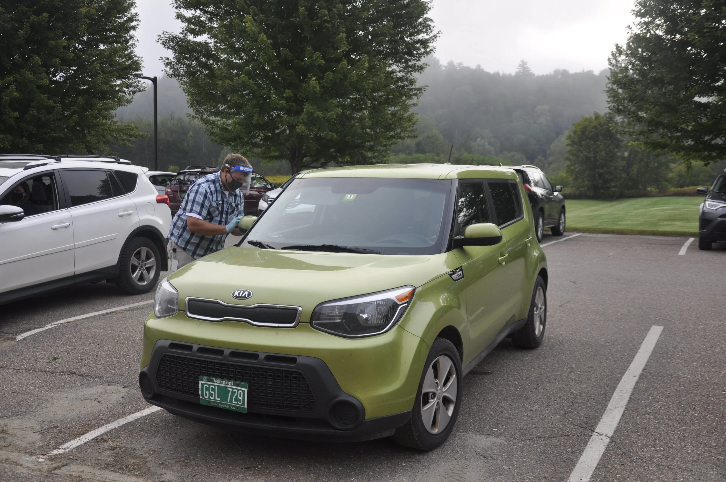   Band director Dan Liptak does a curbside health screening. Photo by Lisa Scagliotti.   
