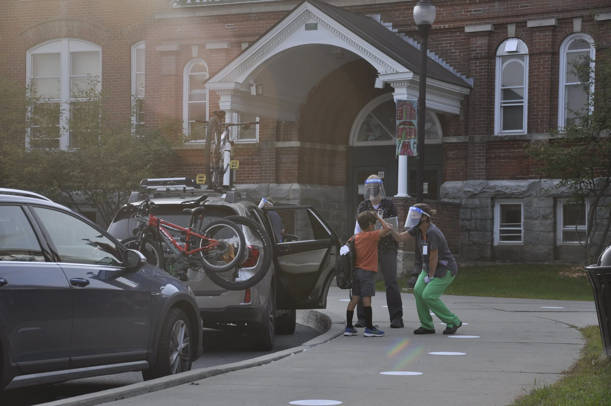   School nurses Allison Conyers and Beth Reilly do a curbside temp check. Photo by Lisa Scagliotti  