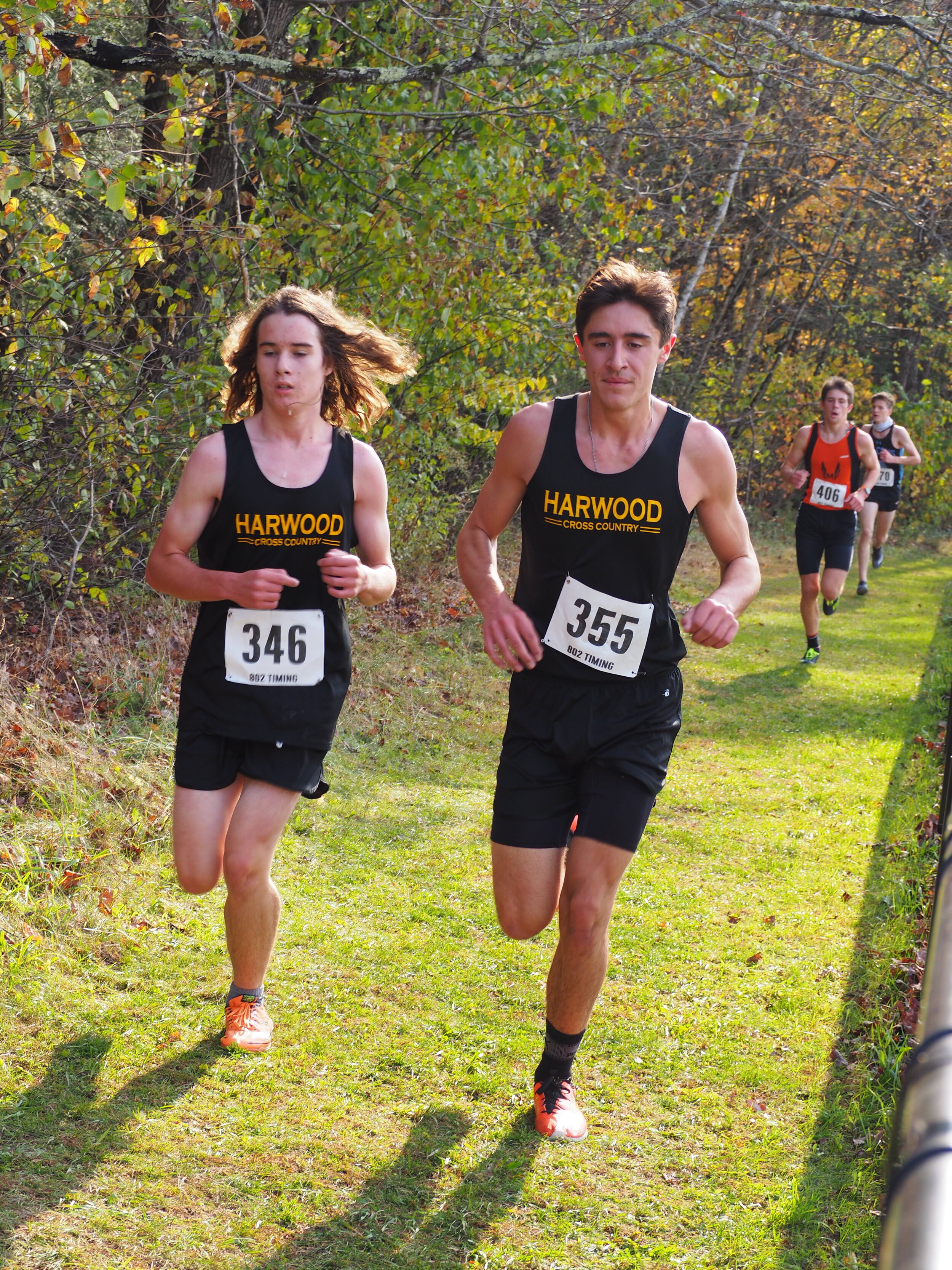   Harwood’s Ebbe Lillis, left, and Vincent Spina, right, keep pace with each other to finish 9th and 10th, helping to seal a win for the Highlander Boys. Photo by Ann Zetterstrom.  